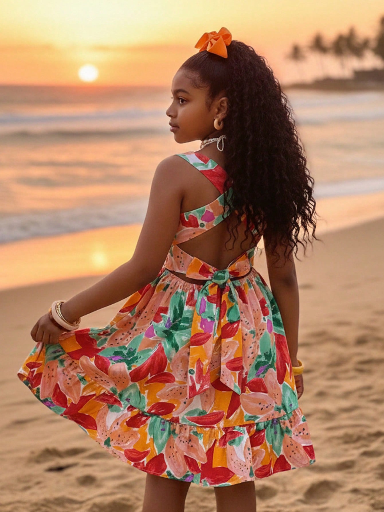 Tween girls multicolor tropical fruit and vegetable print short cami dress with spaghetti straps, bowknot belt detail, high waist, cut-out styling, and flared hem.