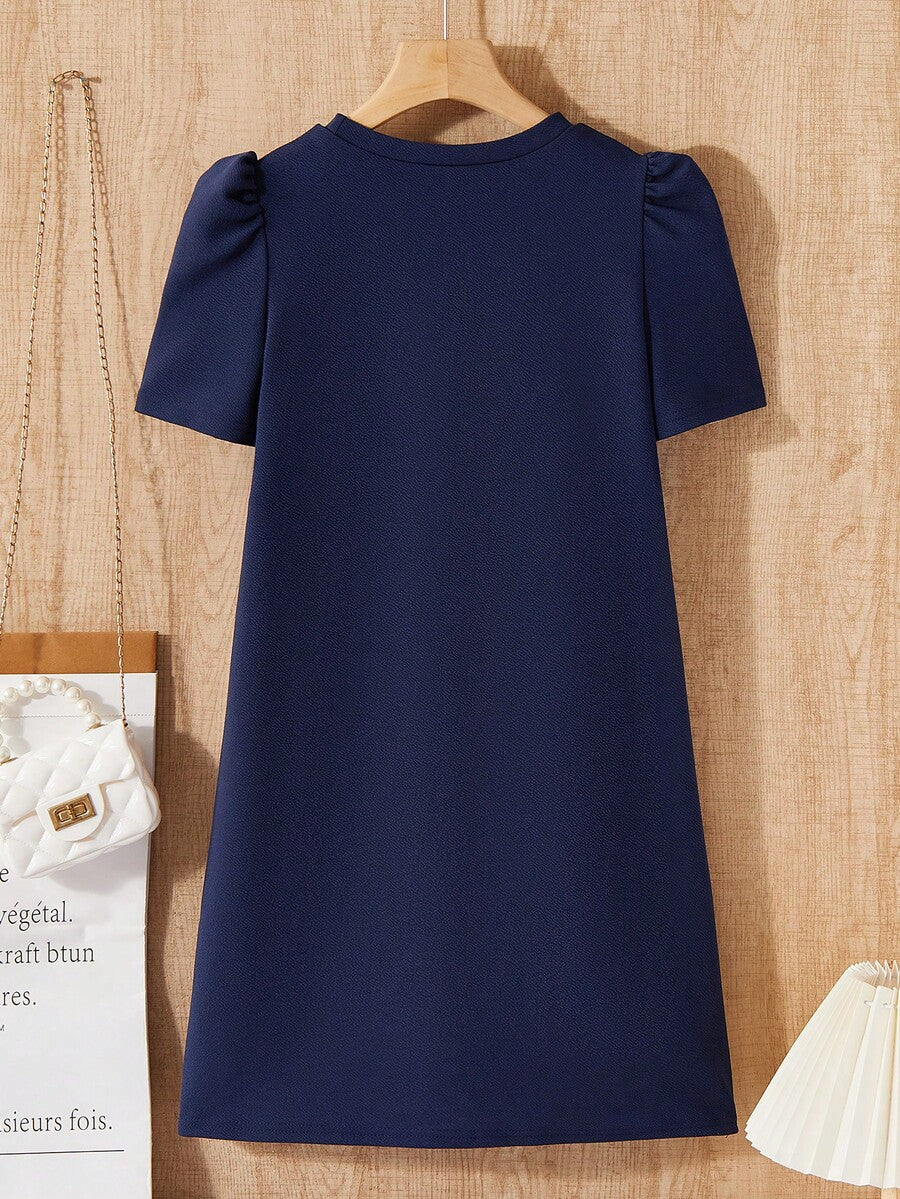 Tween girls apricot short-sleeve pleated smock dress with 3D bow decor and round neckline.