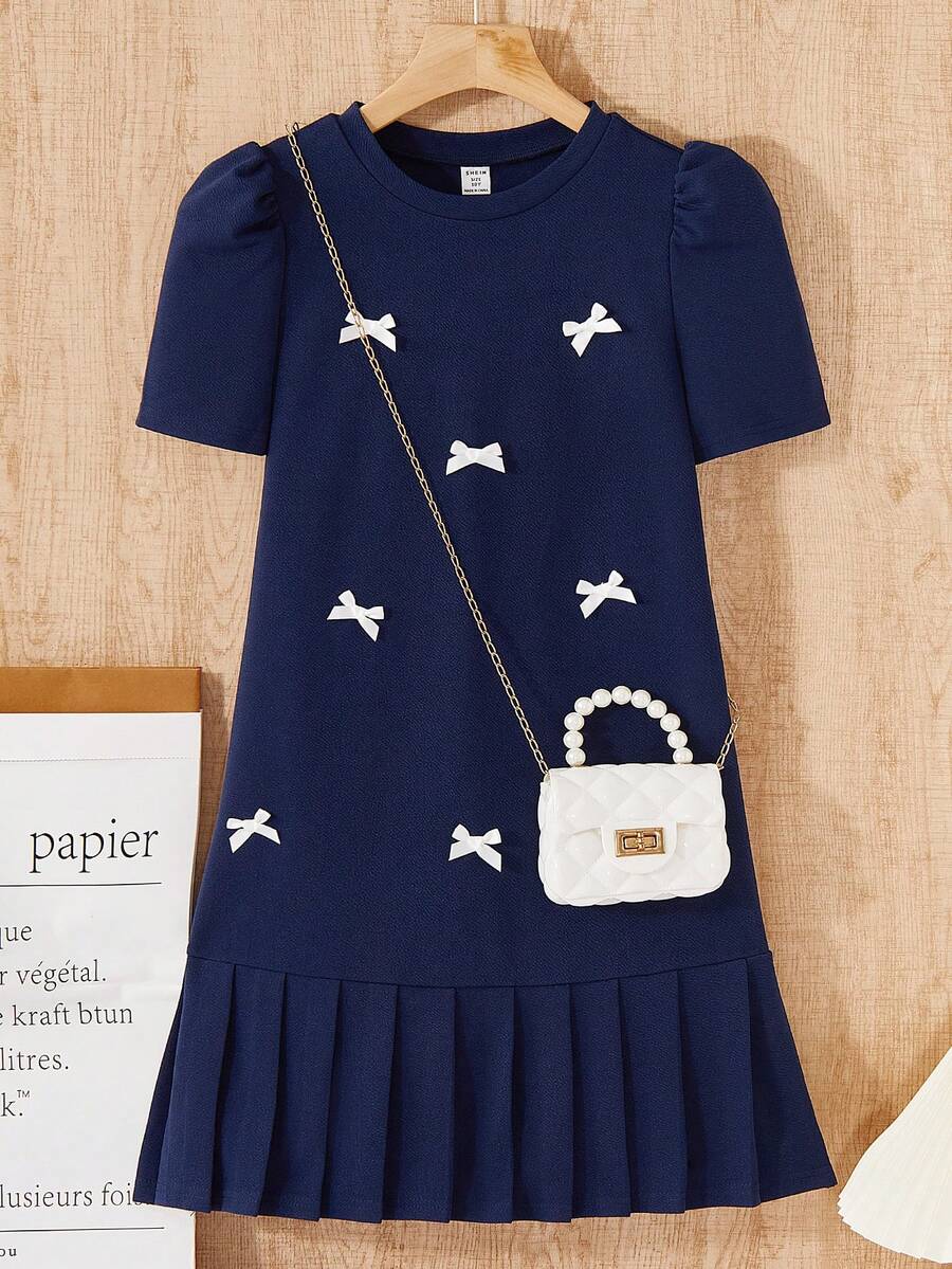 Tween girls apricot short-sleeve pleated smock dress with 3D bow decor and round neckline.
