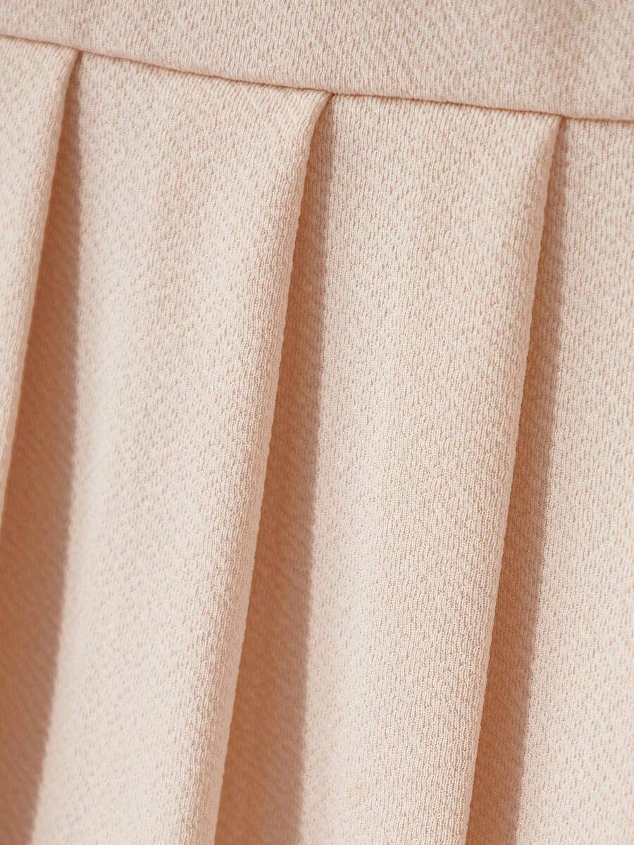 Tween girls apricot short-sleeve pleated smock dress with 3D bow decor and round neckline.
