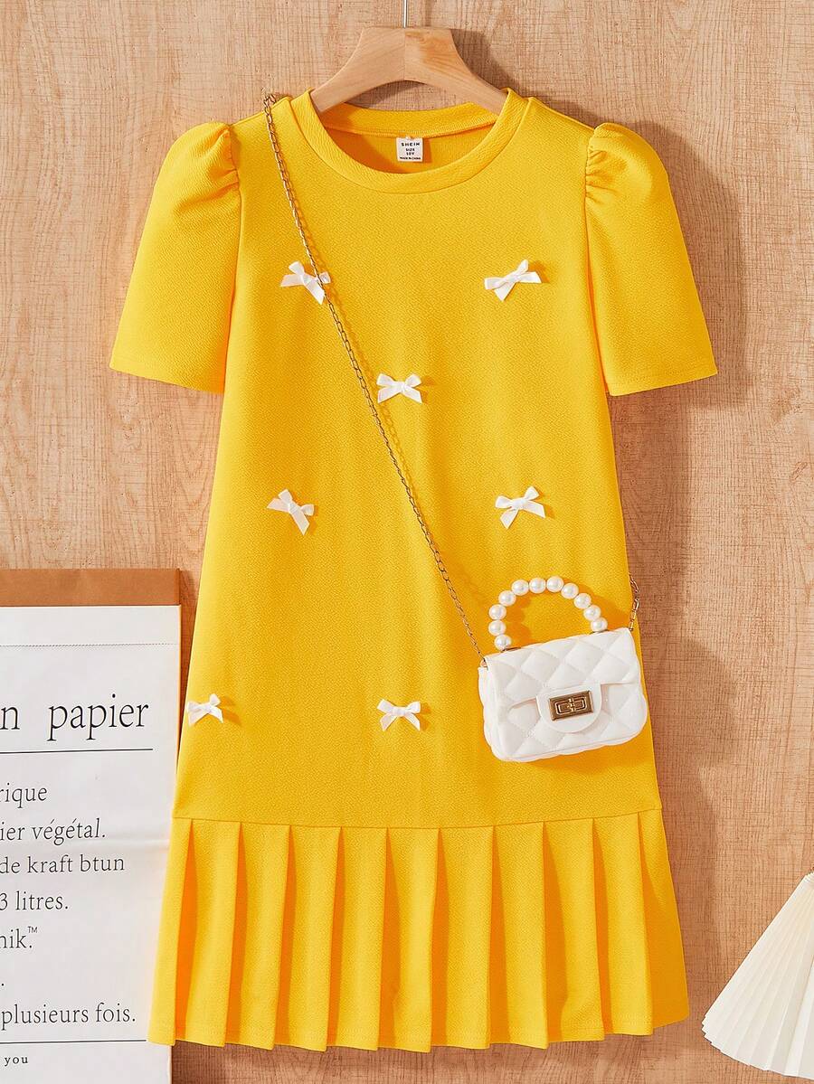 Tween girls apricot short-sleeve pleated smock dress with 3D bow decor and round neckline.