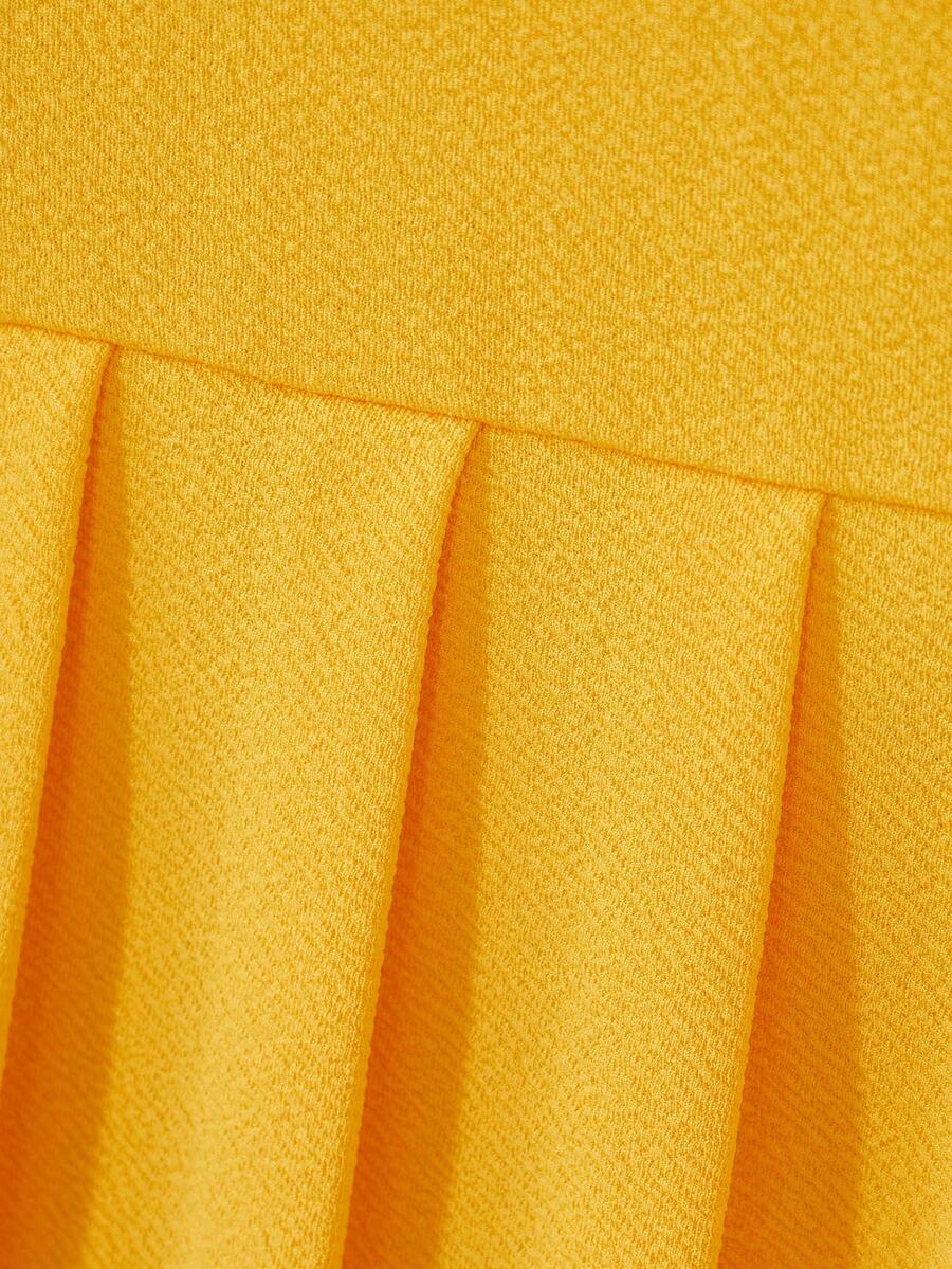 Tween girls apricot short-sleeve pleated smock dress with 3D bow decor and round neckline.