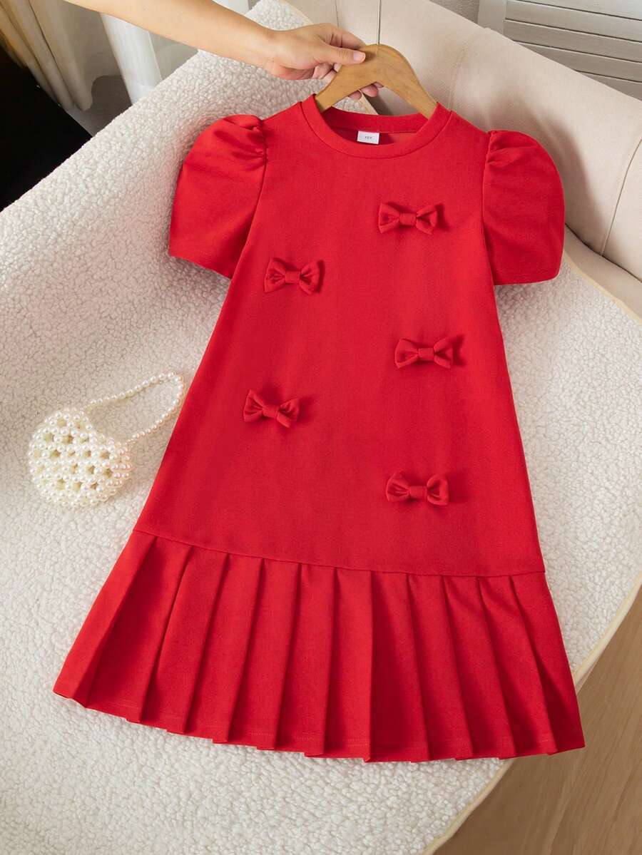 Tween girls apricot short-sleeve pleated smock dress with 3D bow decor and round neckline.