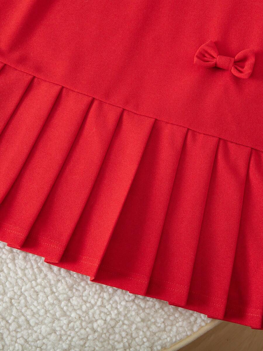 Tween girls apricot short-sleeve pleated smock dress with 3D bow decor and round neckline.