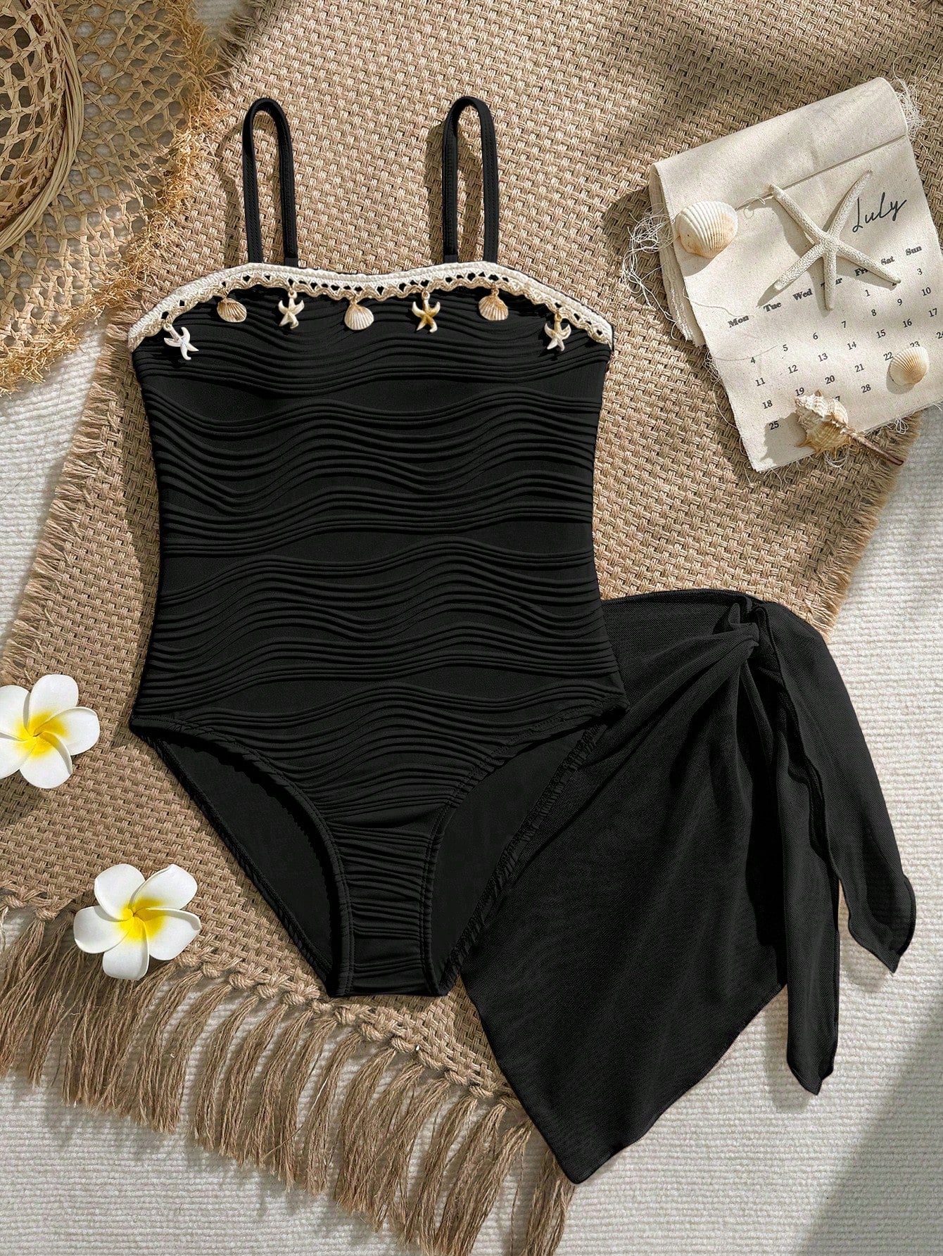 Blue girls one-piece swimsuit with spaghetti straps, textured plain fabric, shell-inspired detail, and matching skirt bottom for beach or pool vacation wear.