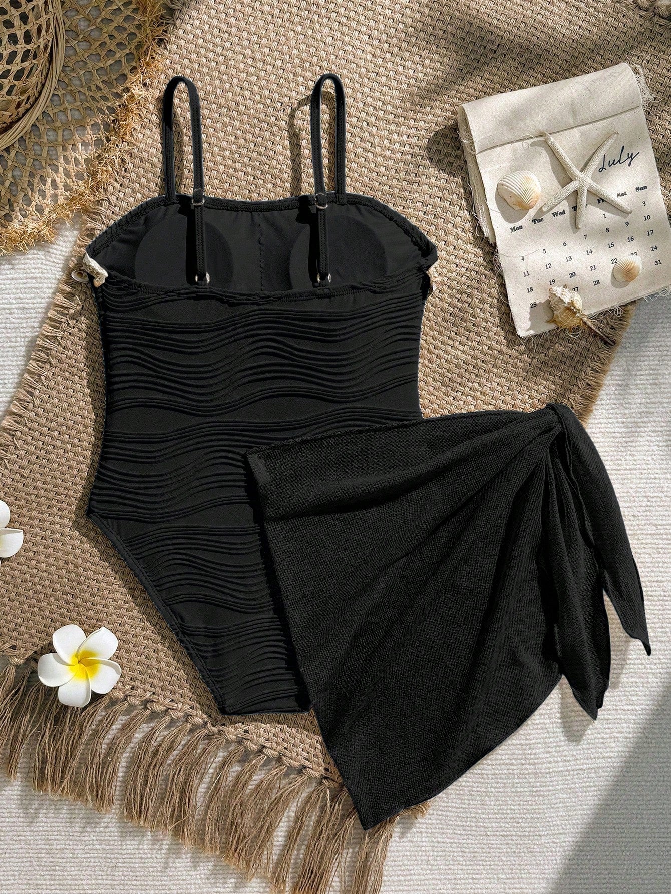 Blue girls one-piece swimsuit with spaghetti straps, textured plain fabric, shell-inspired detail, and matching skirt bottom for beach or pool vacation wear.