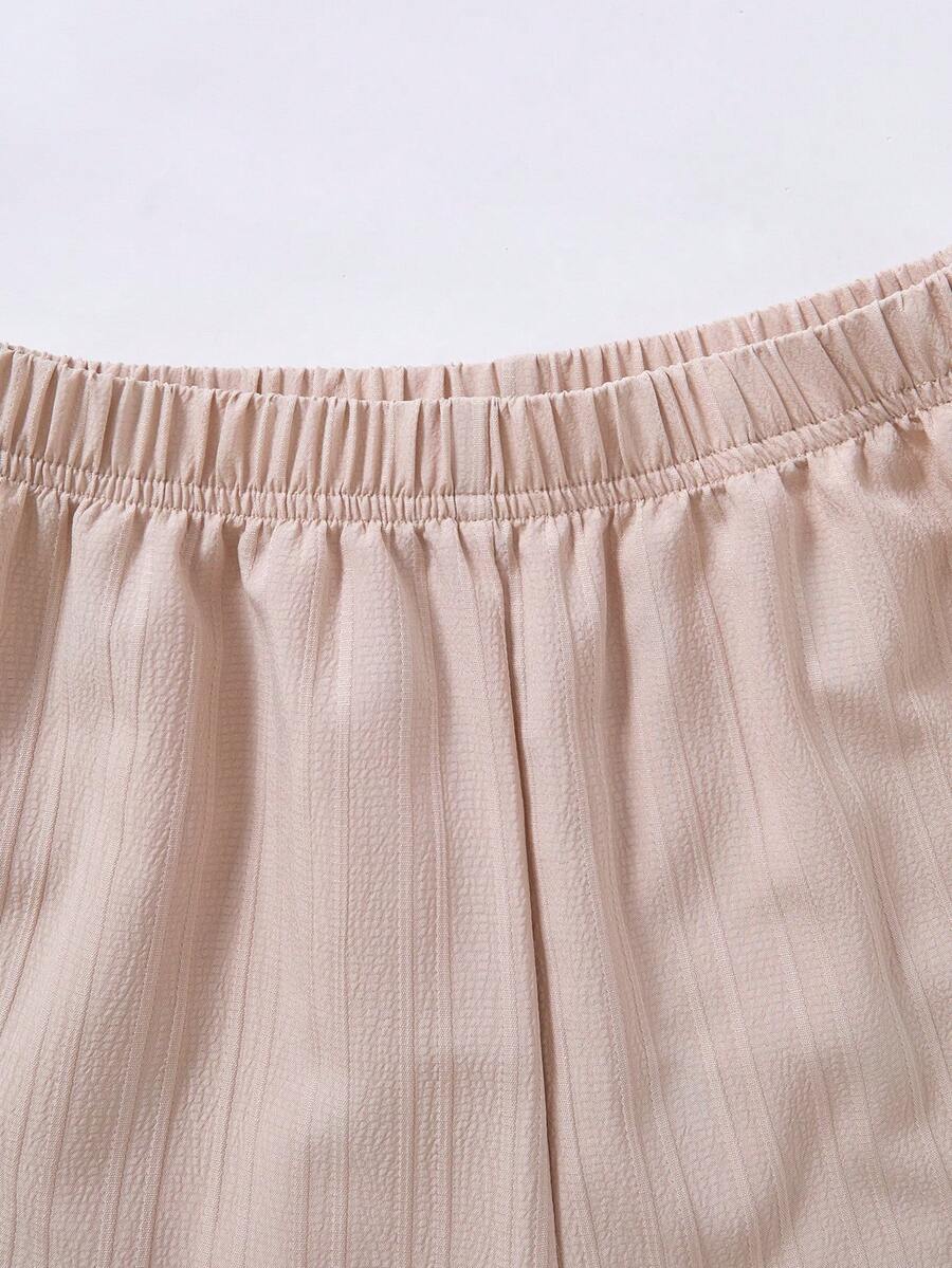 Tween girl wearing an apricot 2-piece outfit set featuring a shirred spaghetti strap short cami top and matching wide-leg long pants.