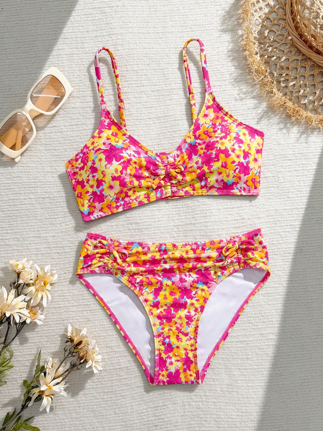 Tween girls 2-piece ditsy floral bikini set featuring a spaghetti strap top with center string detail and matching bottoms with side strings, designed for swimming, vacation, and summer wear.