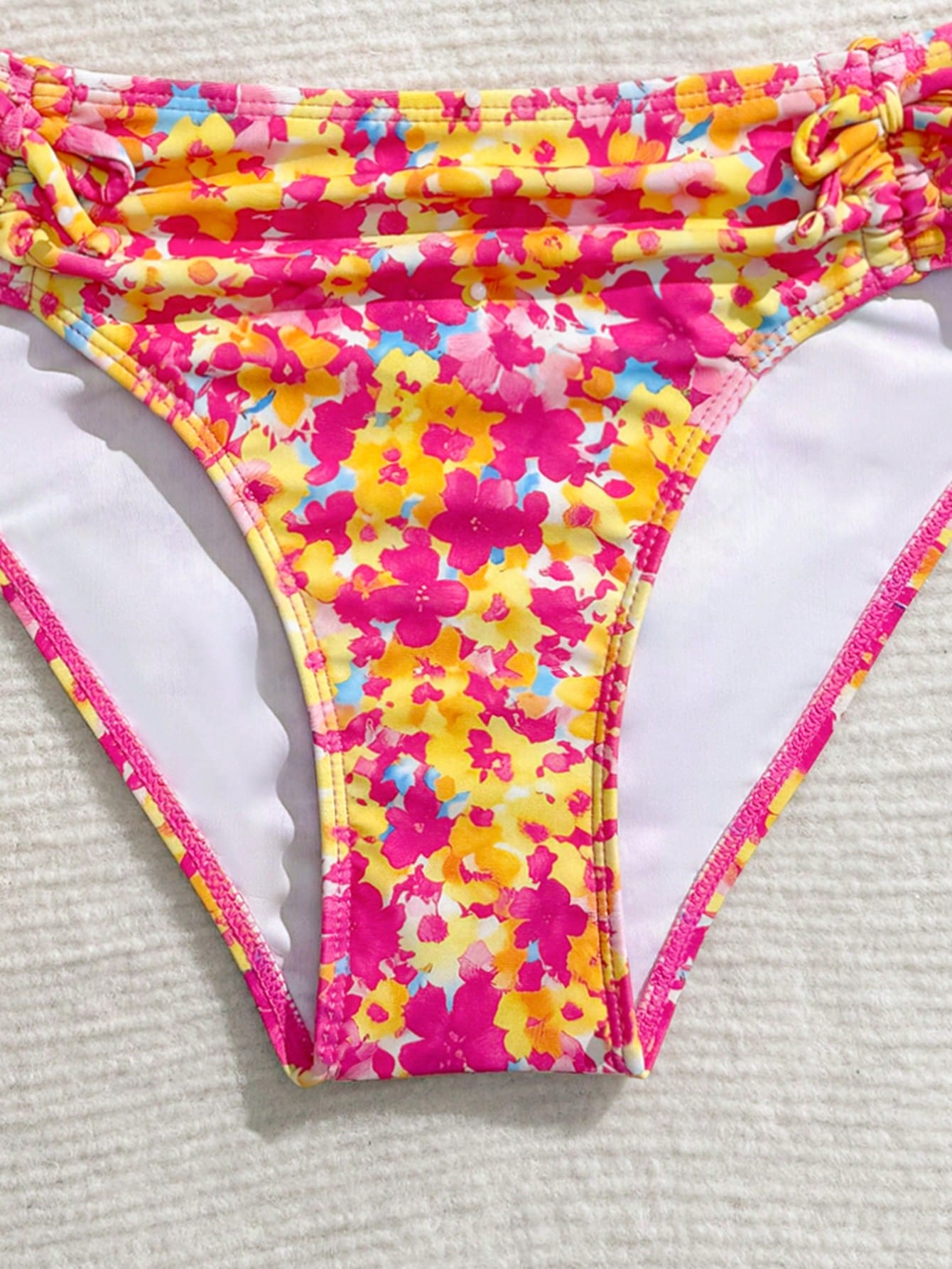 Tween girls 2-piece ditsy floral bikini set featuring a spaghetti strap top with center string detail and matching bottoms with side strings, designed for swimming, vacation, and summer wear.