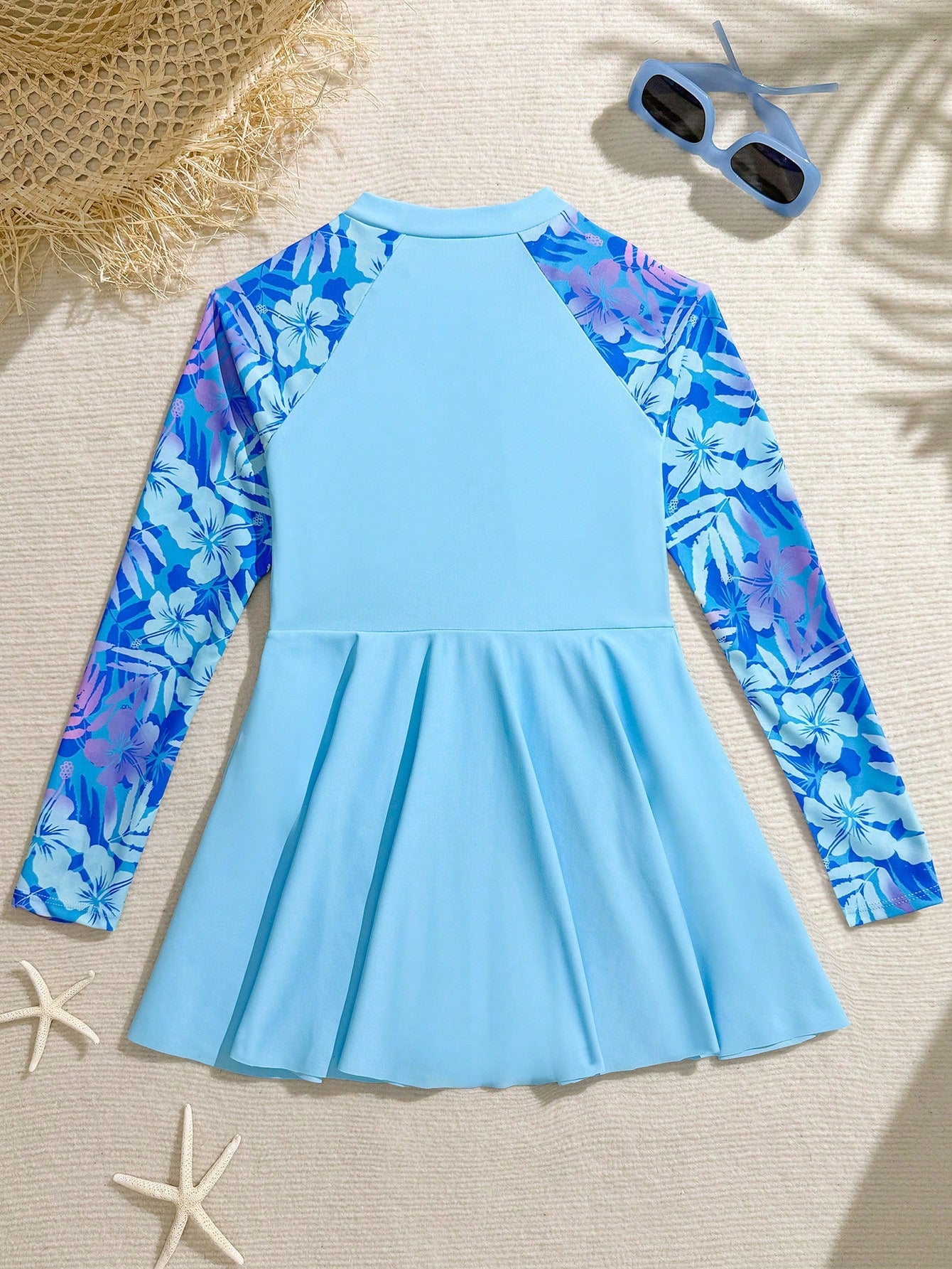 Tween girls one-piece swimsuit in black floral pattern with long sleeves, high neck, front zipper, and a skirt-style bottom.