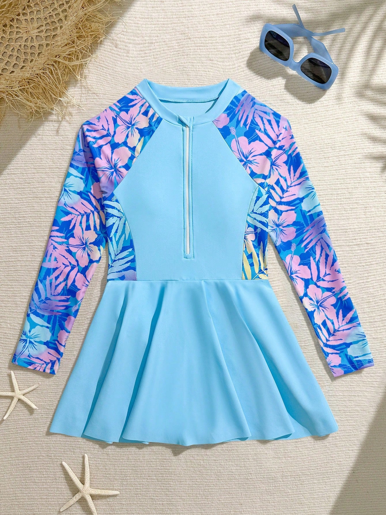 Tween girls one-piece swimsuit in black floral pattern with long sleeves, high neck, front zipper, and a skirt-style bottom.