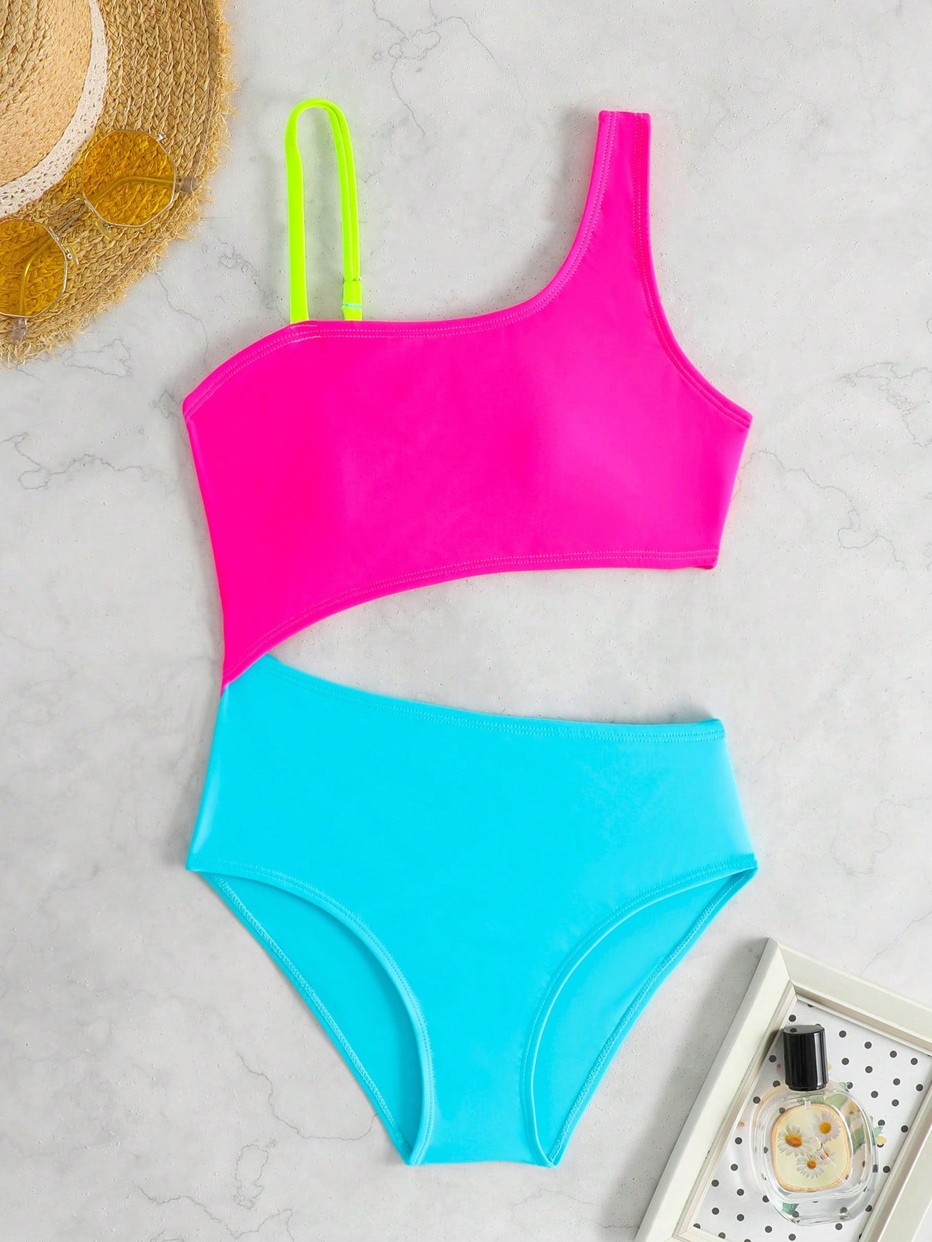 Black one-piece swimsuit for tween girls with cut out detail, spaghetti straps, high waist bottom, wireless bra, and fitted vacation swimwear style.