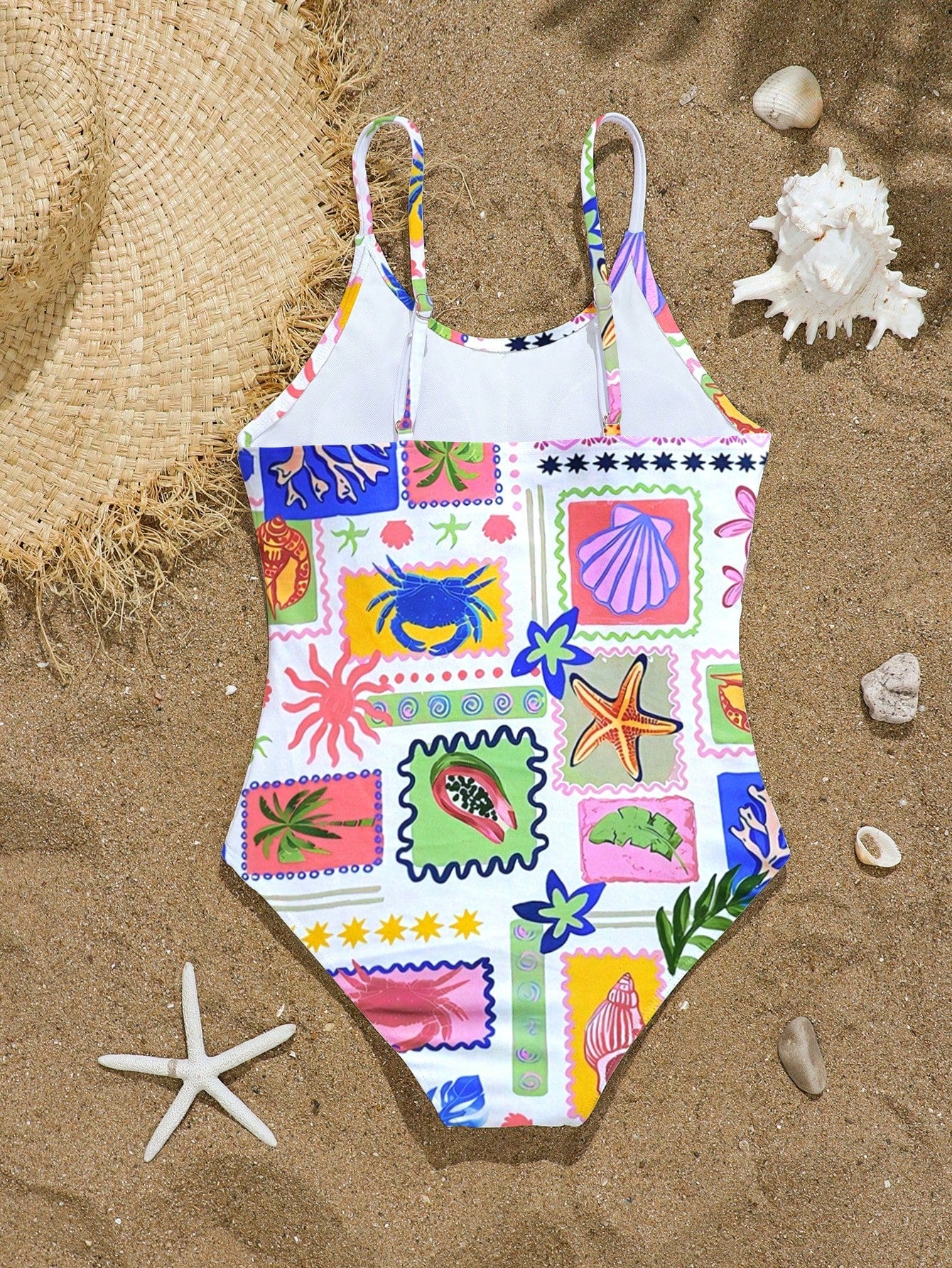 Tween girls one-piece swimsuit with multicolor ocean shell and seahorse all-over print, spaghetti straps, cut-out detail, and lined body for beach or swimming.