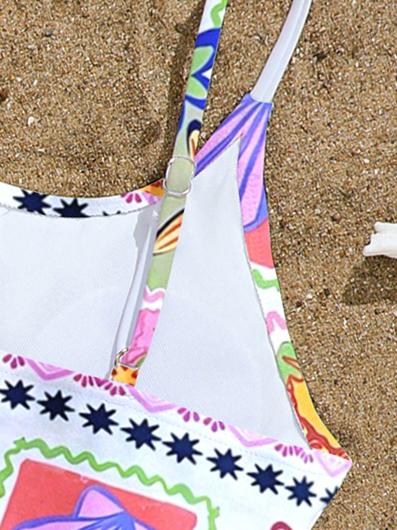 Tween girls one-piece swimsuit with multicolor ocean shell and seahorse all-over print, spaghetti straps, cut-out detail, and lined body for beach or swimming.