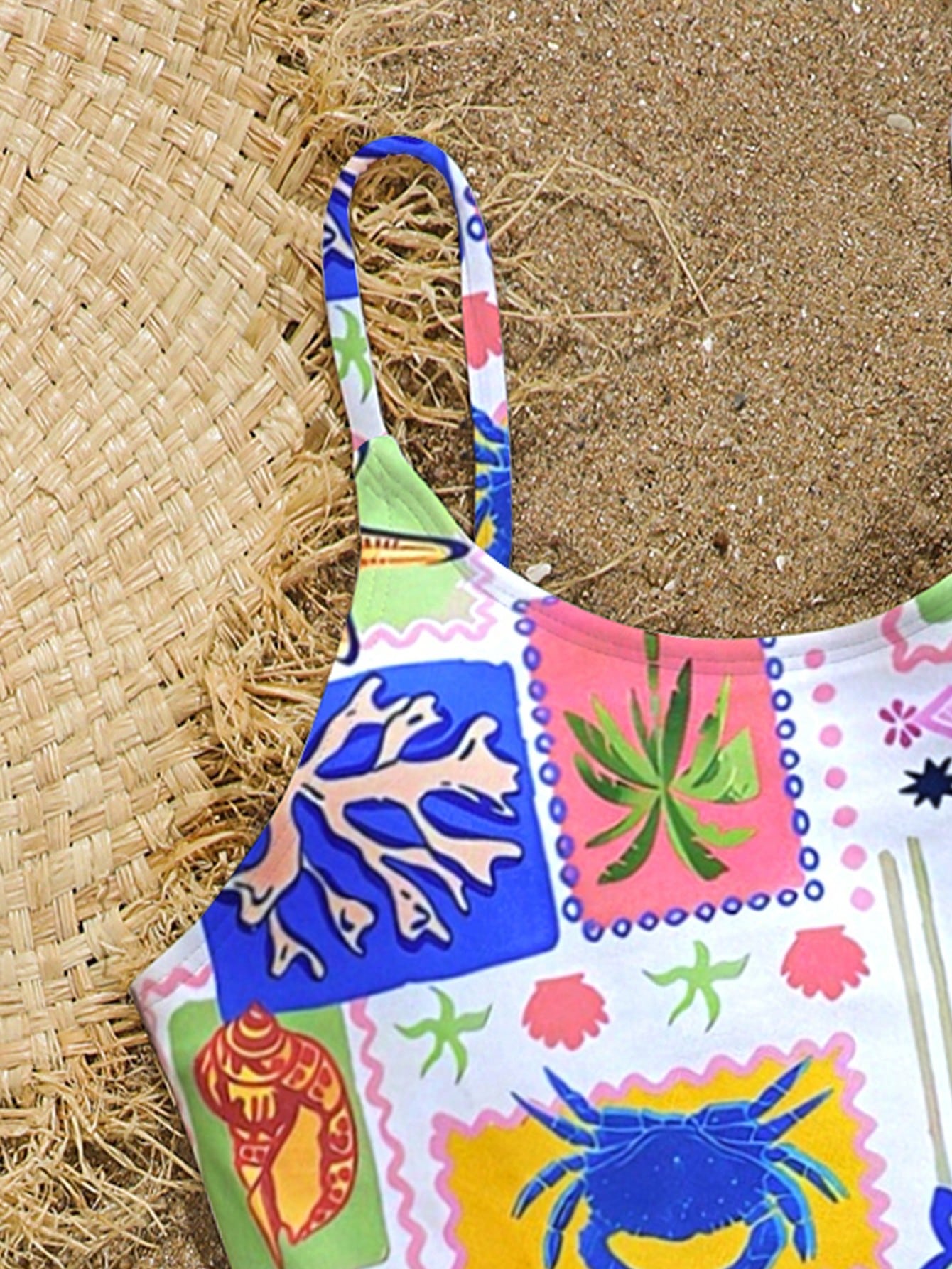 Tween girls one-piece swimsuit with multicolor ocean shell and seahorse all-over print, spaghetti straps, cut-out detail, and lined body for beach or swimming.