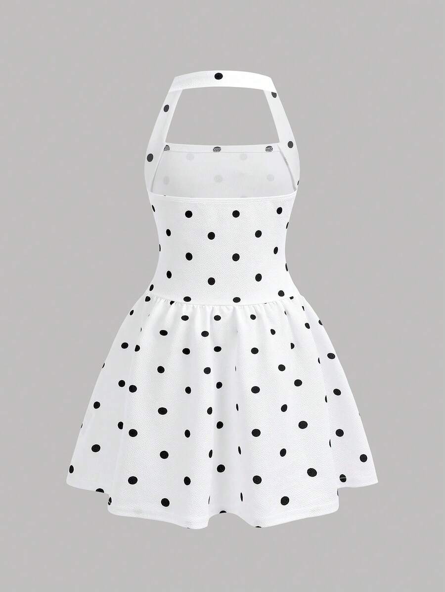 Black sleeveless halter polka dot mini dress for tween girls featuring a high waist and flared hem