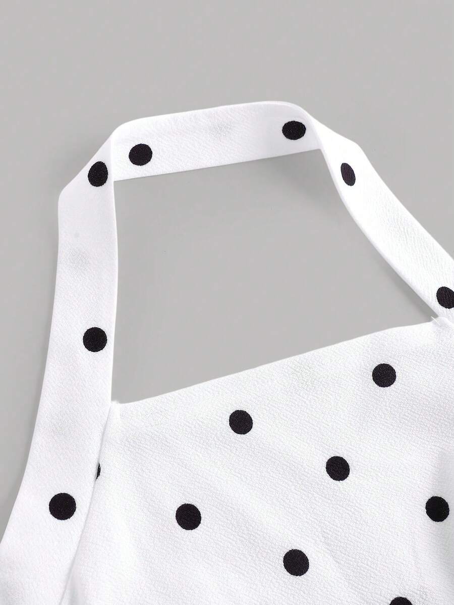 Black sleeveless halter polka dot mini dress for tween girls featuring a high waist and flared hem