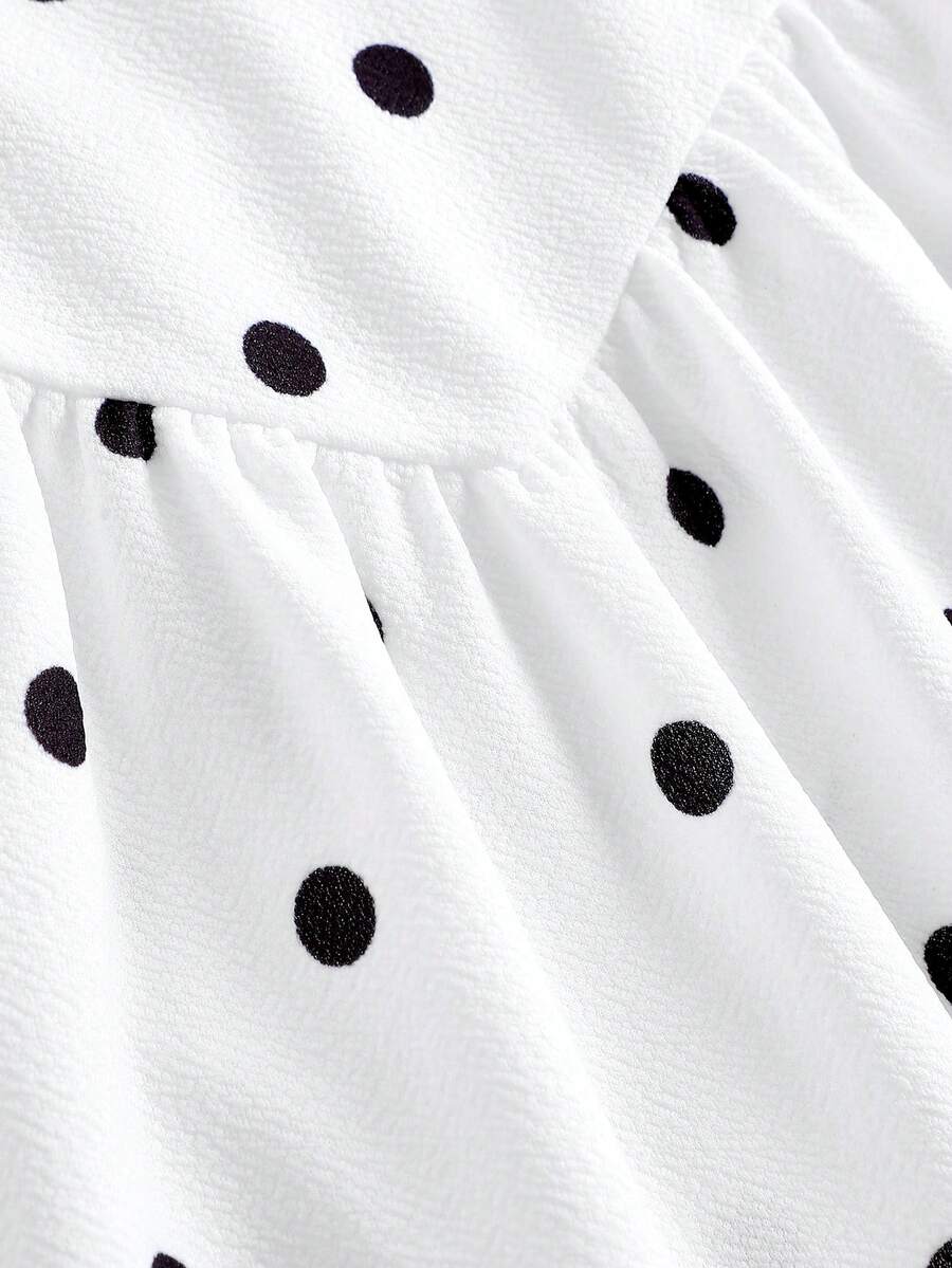 Black sleeveless halter polka dot mini dress for tween girls featuring a high waist and flared hem