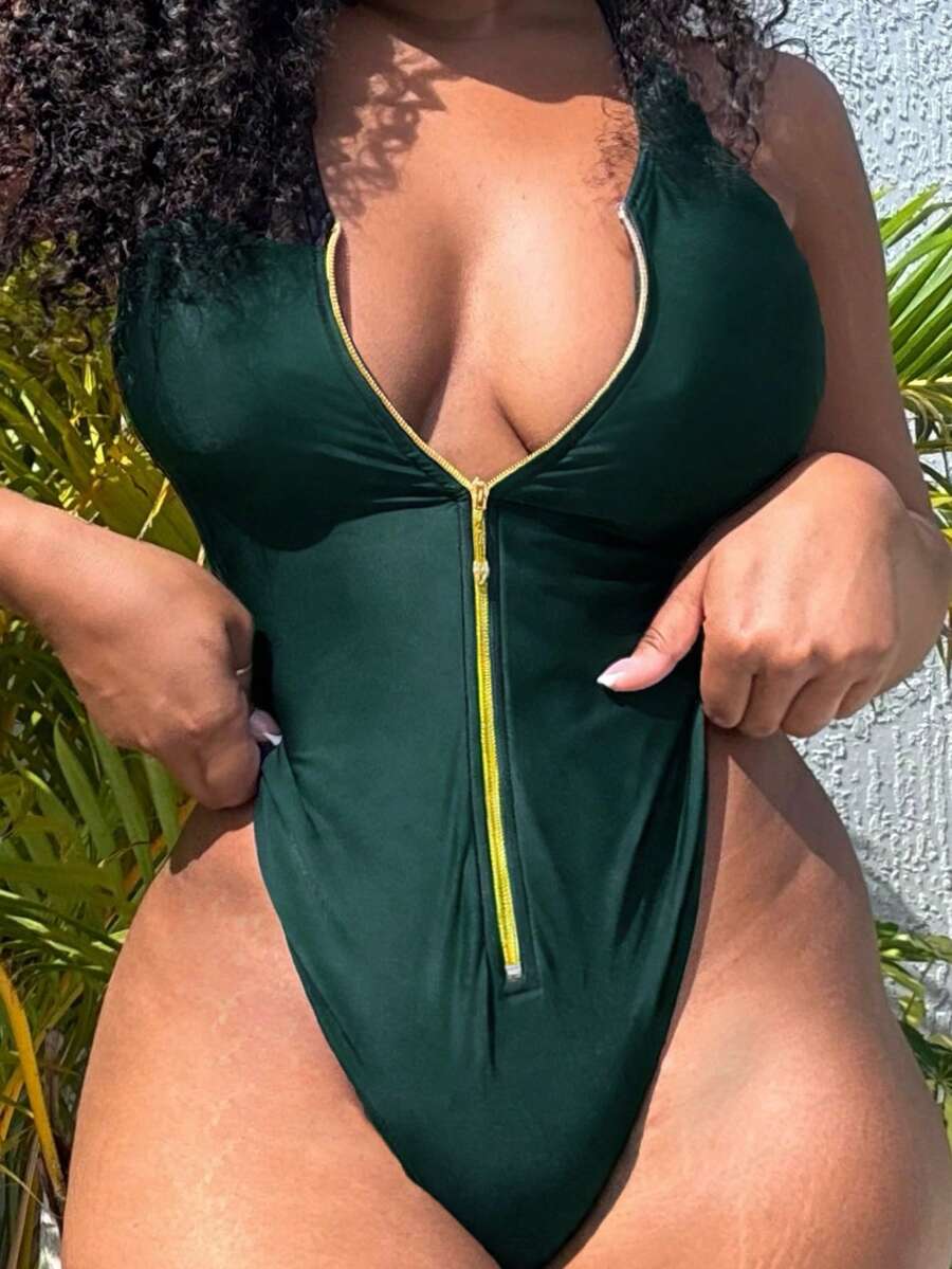 Dark green women's one-piece swimsuit featuring a zipper V-neckline and backless design.
