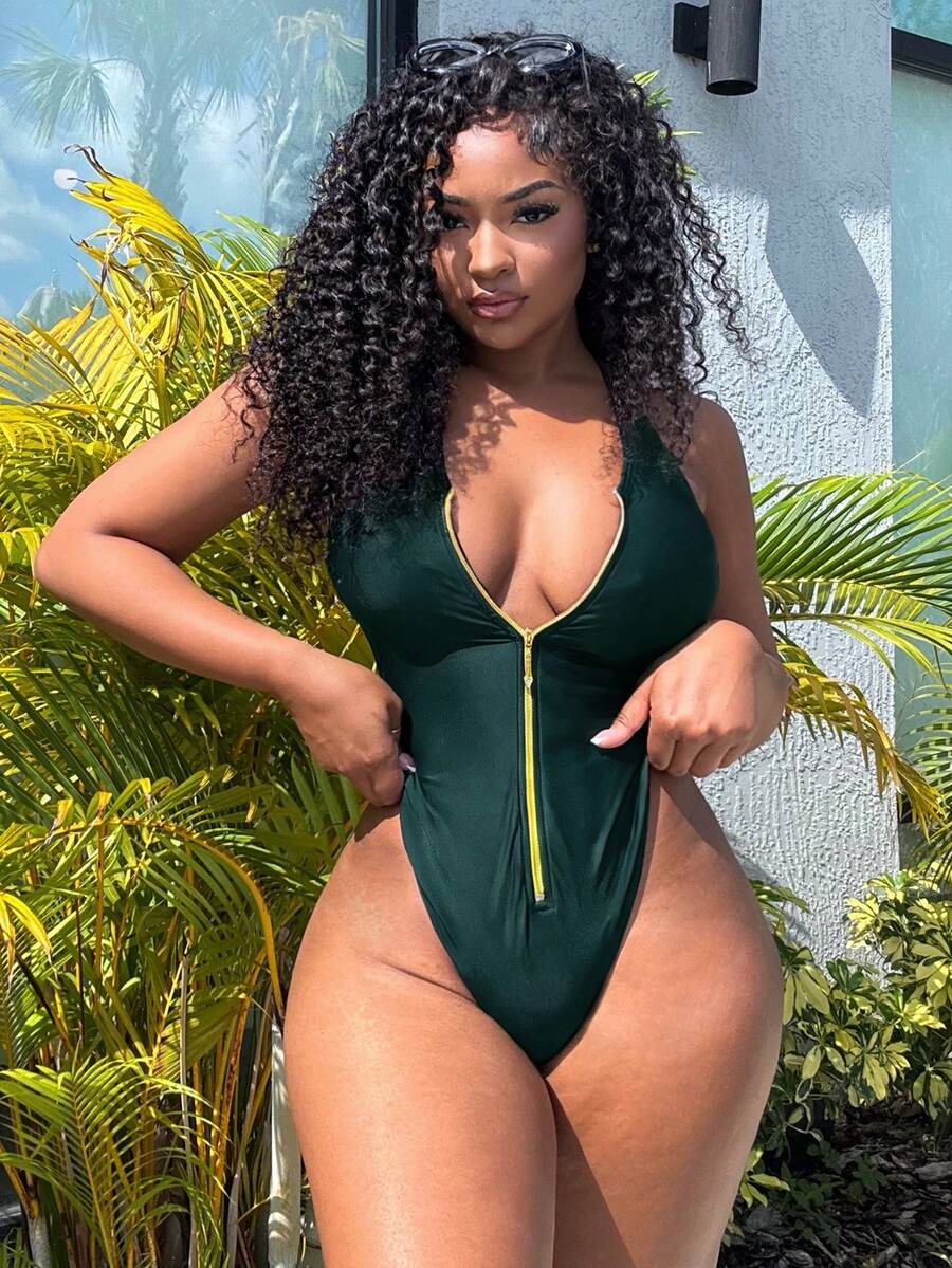 Dark green women's one-piece swimsuit featuring a zipper V-neckline and backless design.