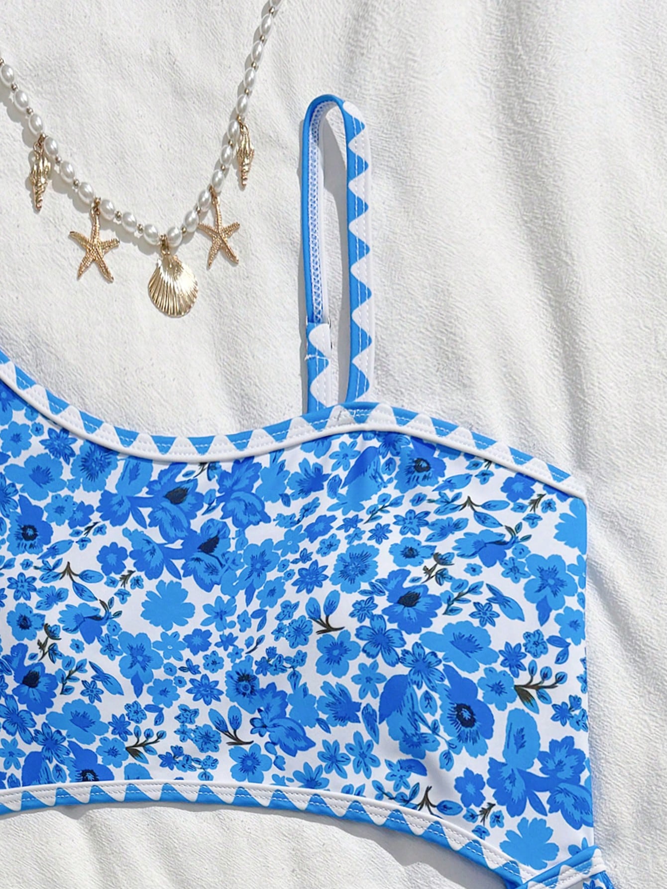Tween girls one-piece swimsuit featuring an asymmetric neckline, pendant decor, plain design, wireless bra, high-cut bottom, and medium-stretch fabric.