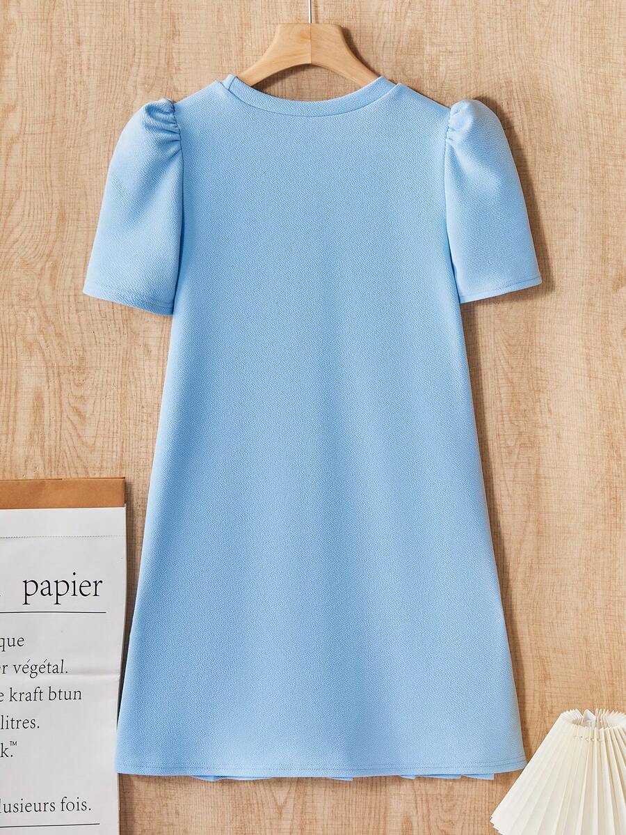 Tween girls apricot short-sleeve pleated smock dress with 3D bow decor and round neckline.
