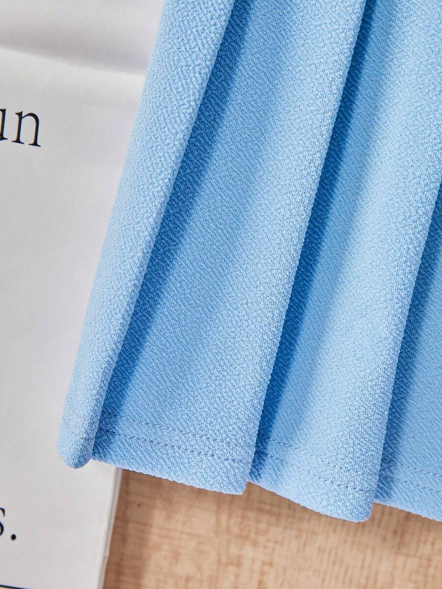 Tween girls apricot short-sleeve pleated smock dress with 3D bow decor and round neckline.