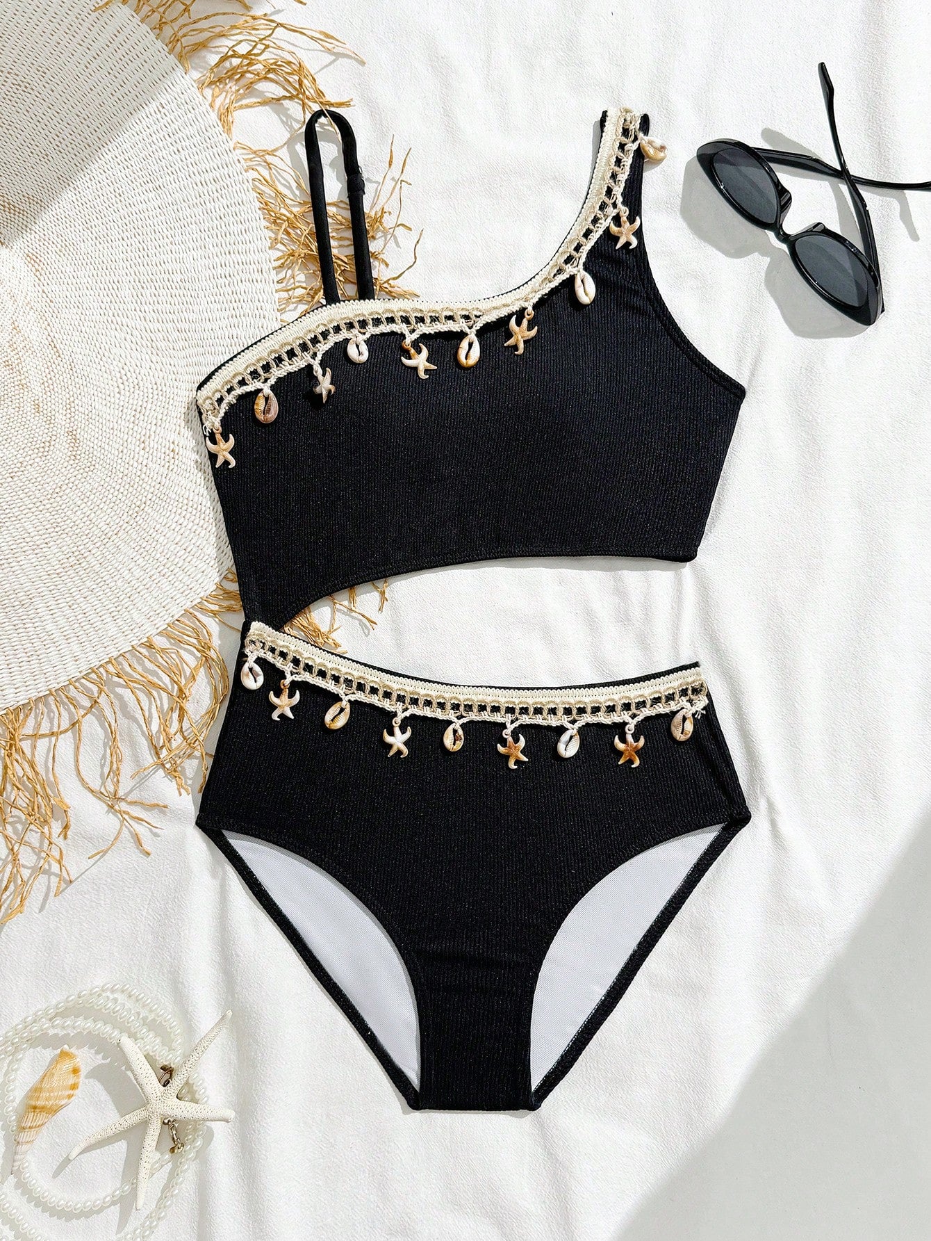 Girls black one-piece swimsuit with asymmetrical neckline, cutout waist detail, colorblock design, and medium-stretch swimsuit fabric for beach and pool wear.