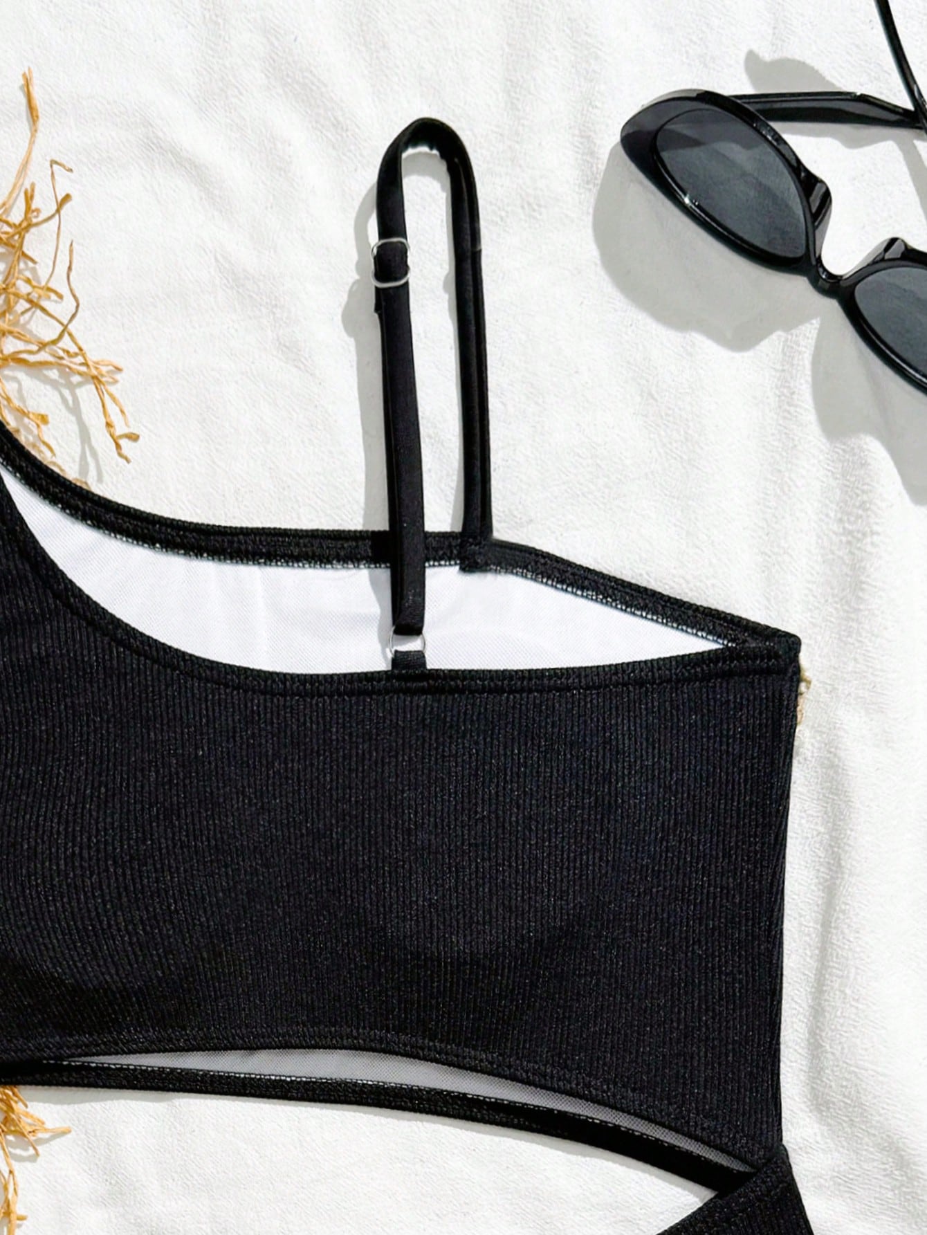 Girls black one-piece swimsuit with asymmetrical neckline, cutout waist detail, colorblock design, and medium-stretch swimsuit fabric for beach and pool wear.