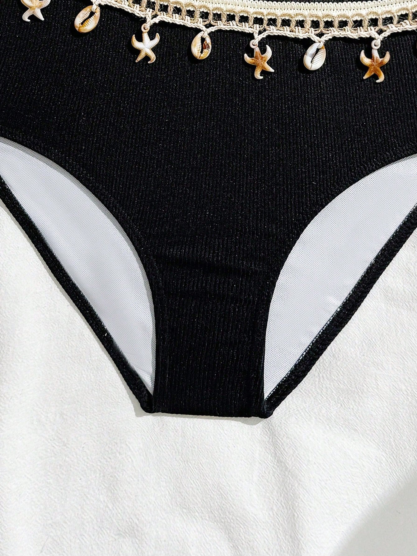 Girls black one-piece swimsuit with asymmetrical neckline, cutout waist detail, colorblock design, and medium-stretch swimsuit fabric for beach and pool wear.