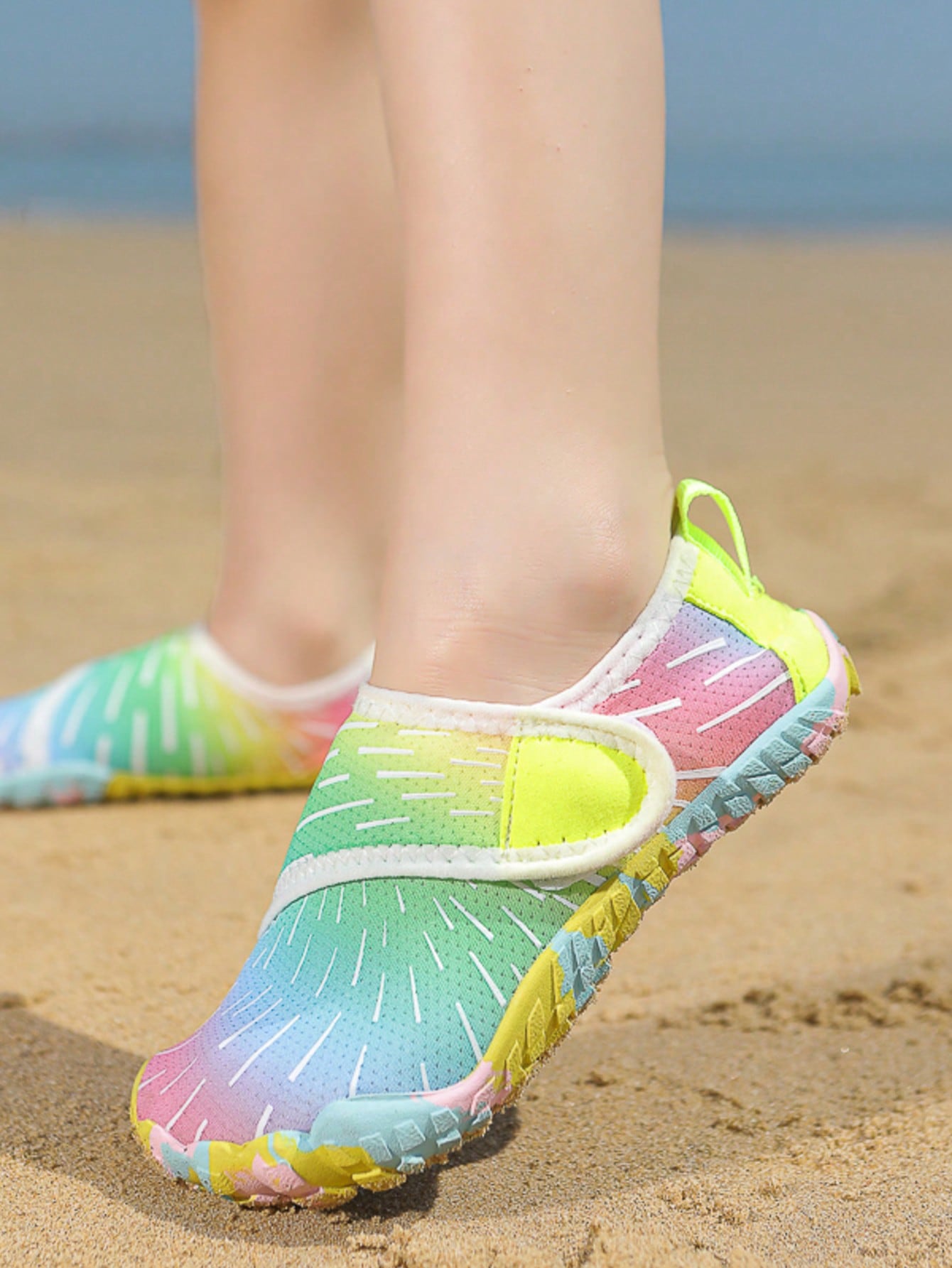 Multicolor kids water shoes with breathable mesh upper, luminous accents, and durable rubber sole with hook and loop closure.