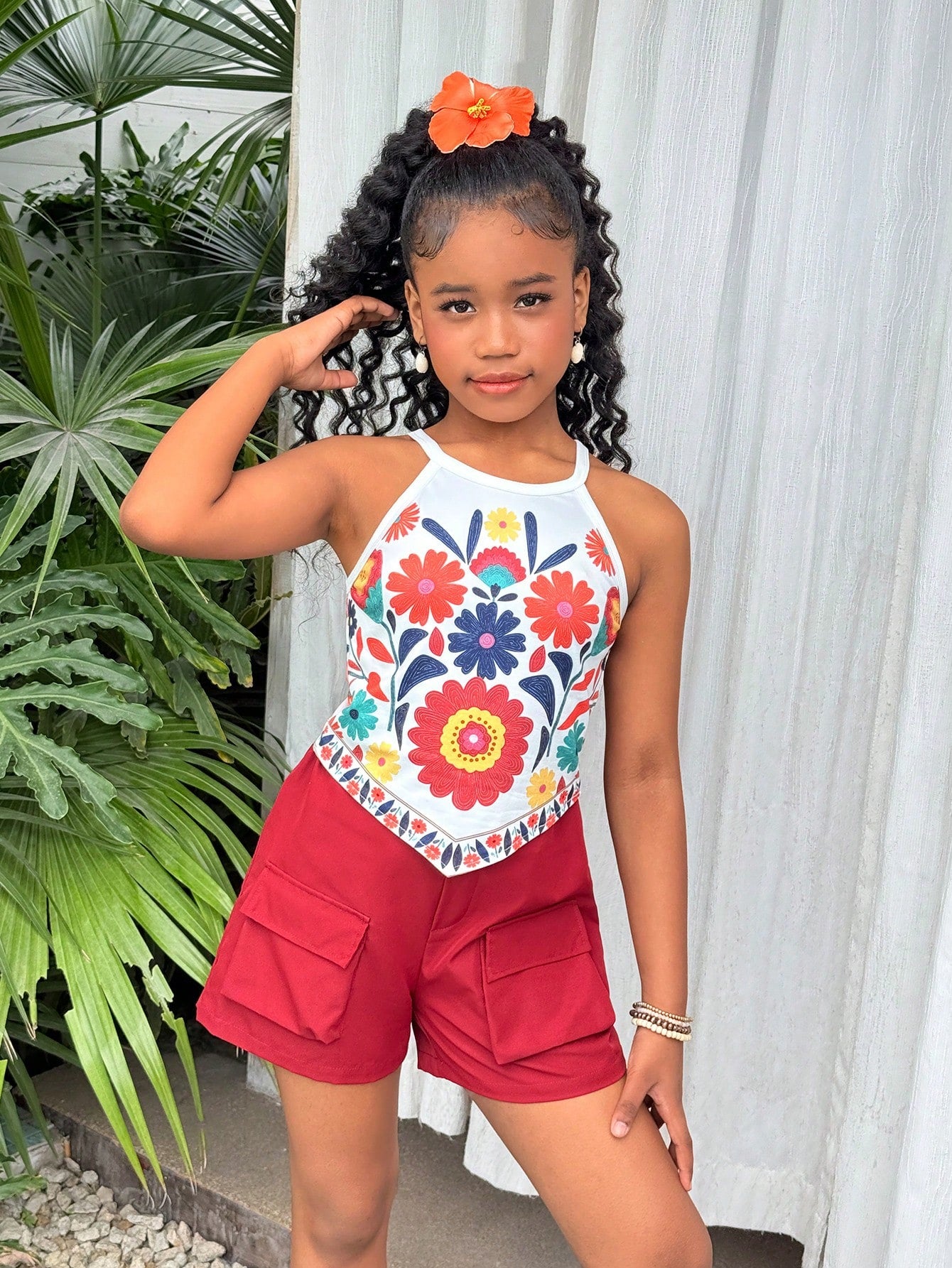 Girls 2-piece vacation outfit set with sleeveless halter knit crop top and graphic cargo shorts.