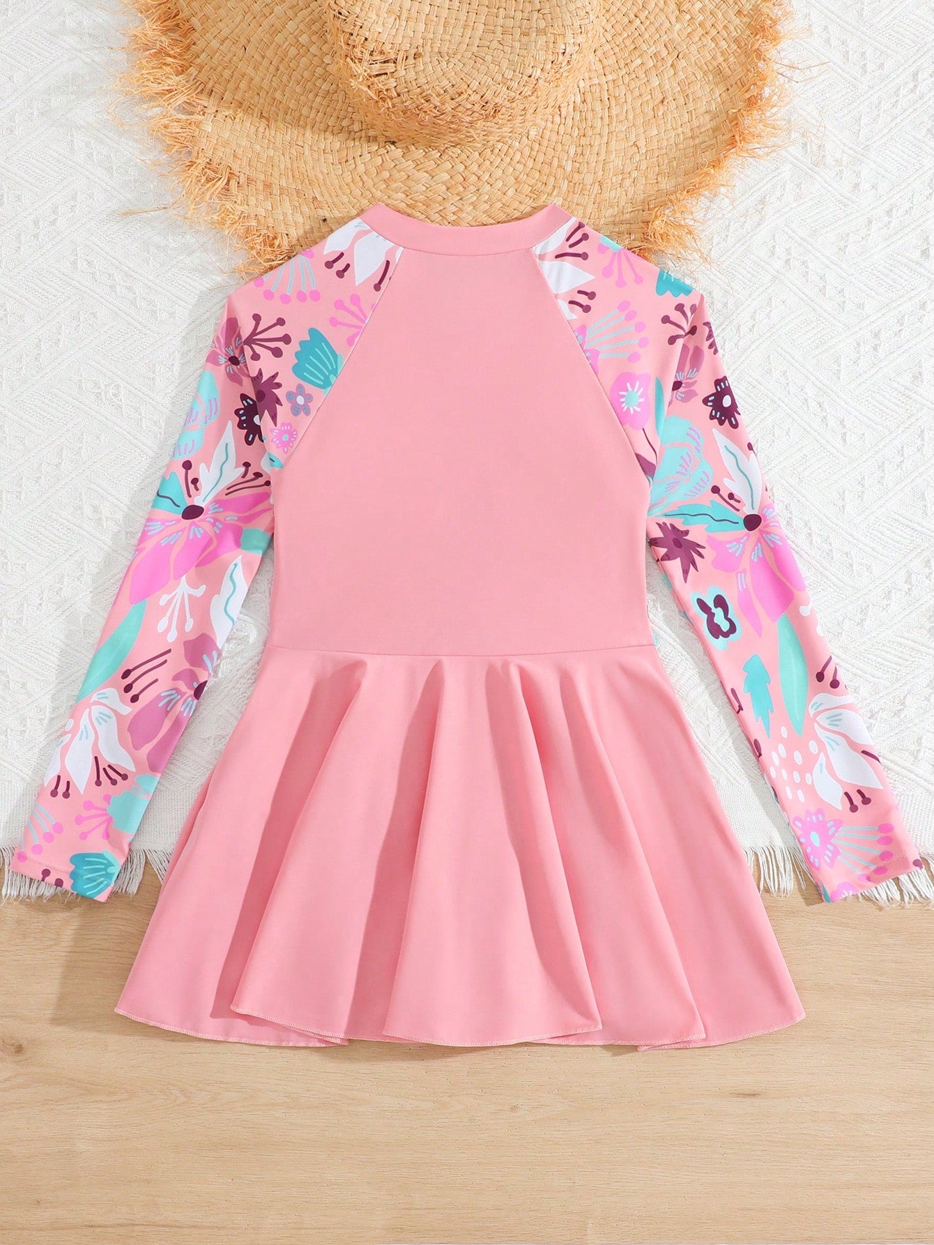 Tween girls one-piece swimsuit in black floral pattern with long sleeves, high neck, front zipper, and a skirt-style bottom.