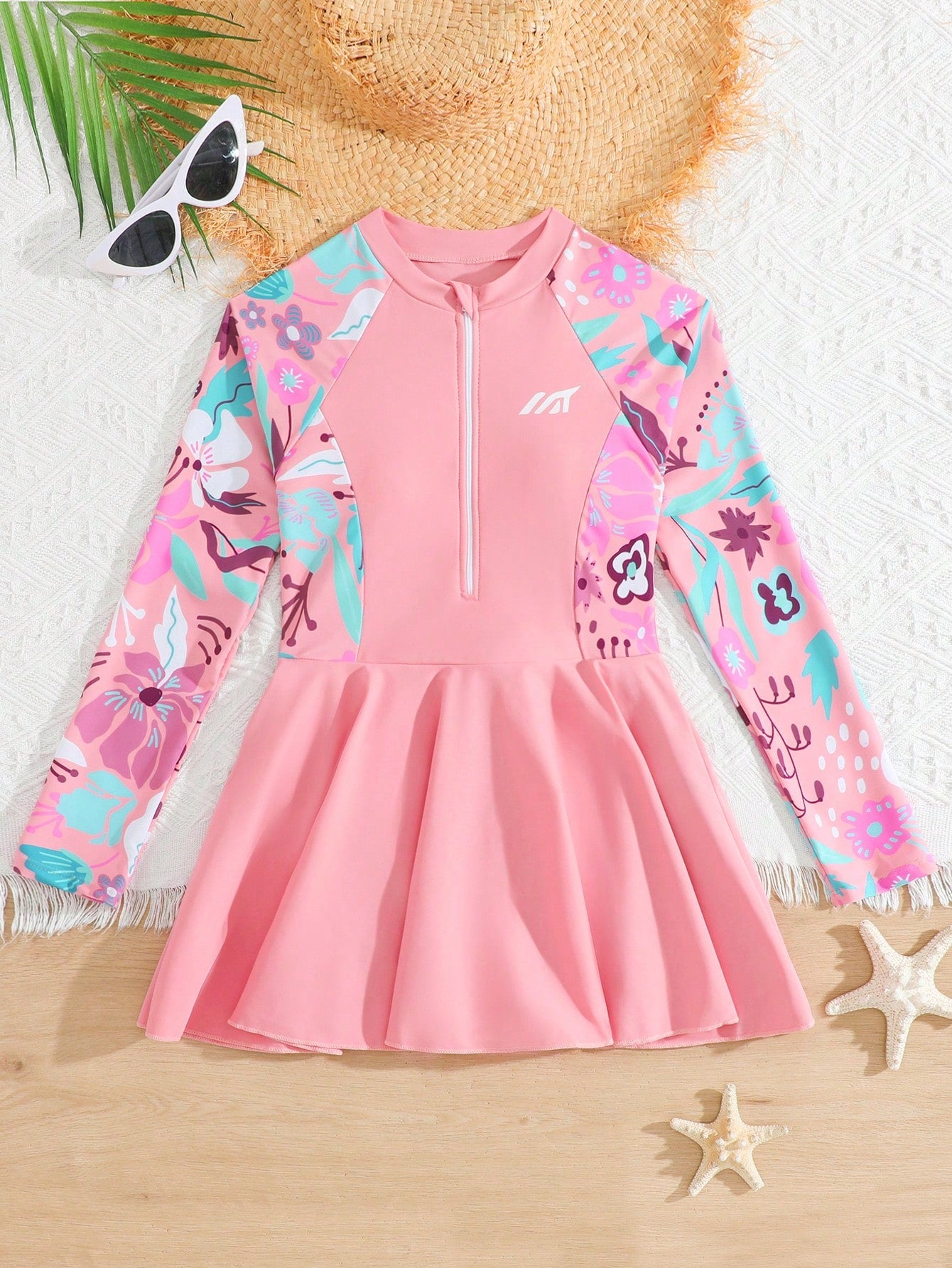 Tween girls one-piece swimsuit in black floral pattern with long sleeves, high neck, front zipper, and a skirt-style bottom.
