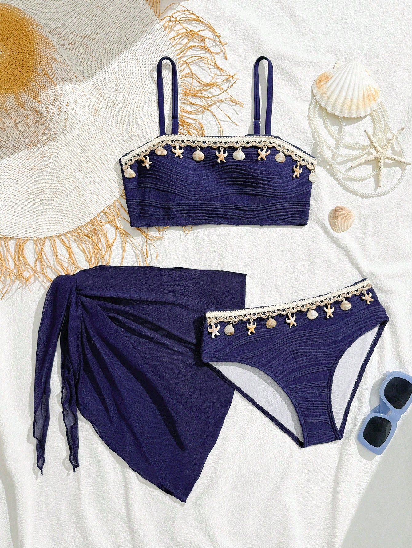 Tween girls bikini set with shell and starfish woven band details, spaghetti strap sleeveless top, and mid-waist skirt-style bottom in blue.