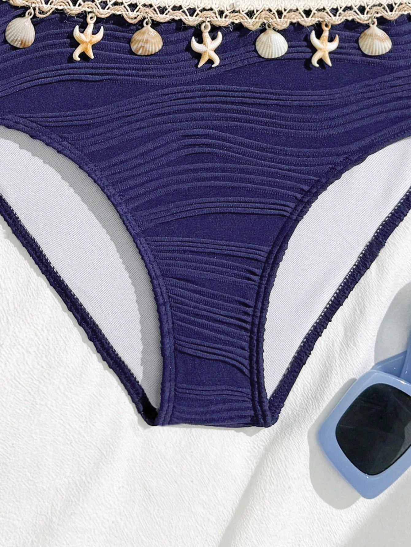Tween girls bikini set with shell and starfish woven band details, spaghetti strap sleeveless top, and mid-waist skirt-style bottom in blue.
