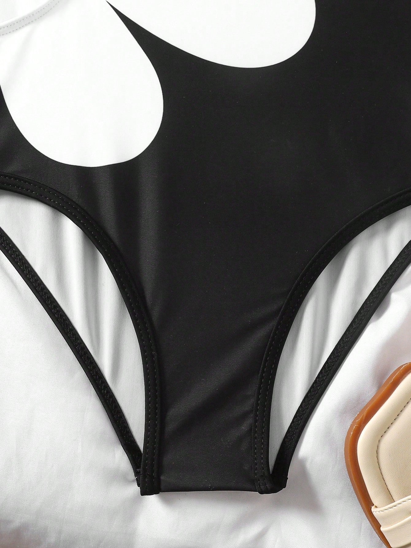 Tween girls' black and white one-piece swimsuit with striped patchwork design, scoop neck, asymmetrical cut-out detail, and fitted vacation swimwear style.