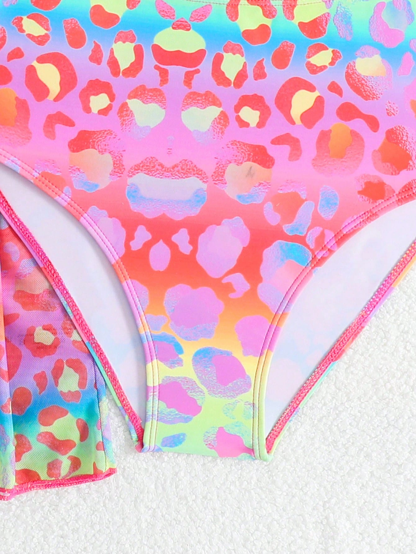 Tween girls multicolor 2-piece swimsuit set with scoop neck, cut-out details, patterned design, shorts-style bottoms, and sheer UV protection cover-up for beach and pool vacations.