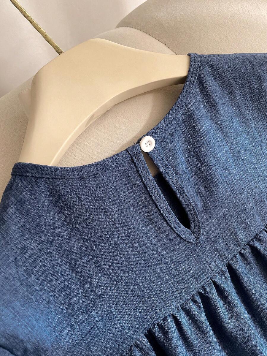Tween girl wearing an Army Green textured short sleeve smock midi dress with round neck and ruffle flounce hem.