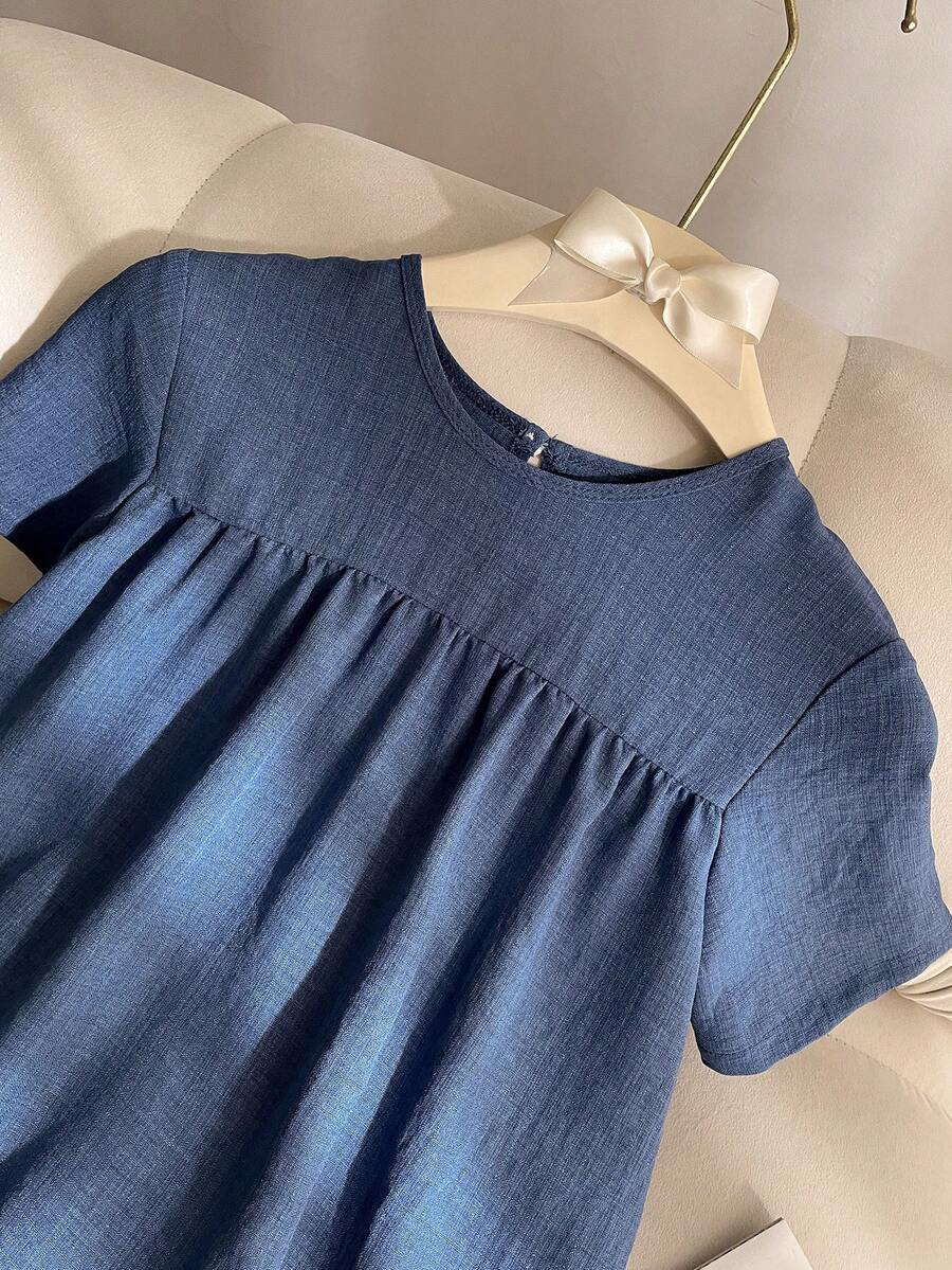 Tween girl wearing an Army Green textured short sleeve smock midi dress with round neck and ruffle flounce hem.