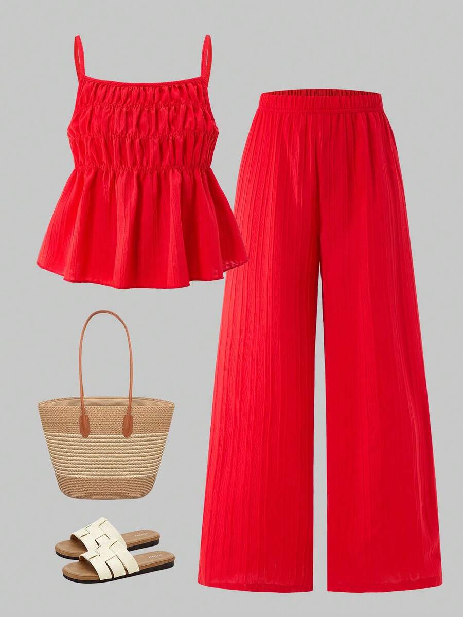 Tween girl wearing an apricot 2-piece outfit set featuring a shirred spaghetti strap short cami top and matching wide-leg long pants.