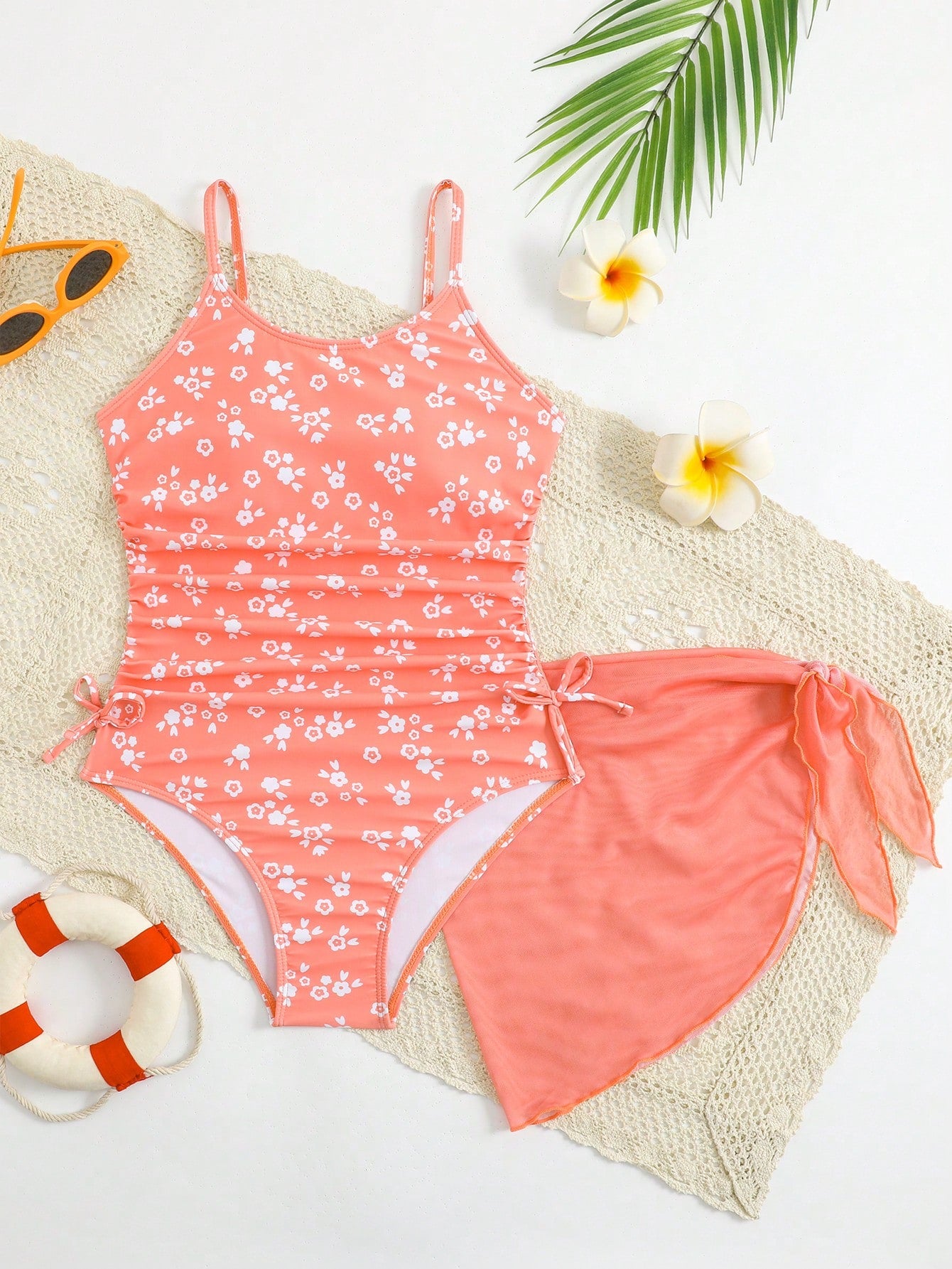 Tween girls 2-piece swimsuit in black with pink floral print, featuring spaghetti straps, bow decor, mesh detail, and a skirted mid-waist bottom. Sleeveless vacation-style swim set with medium-stretch fabric.