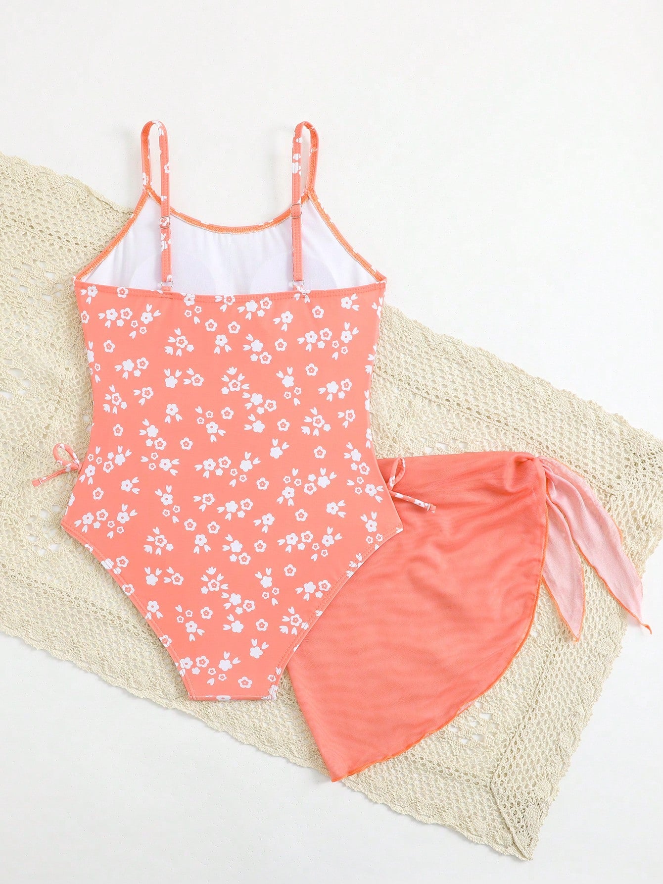 Tween girls 2-piece swimsuit in black with pink floral print, featuring spaghetti straps, bow decor, mesh detail, and a skirted mid-waist bottom. Sleeveless vacation-style swim set with medium-stretch fabric.