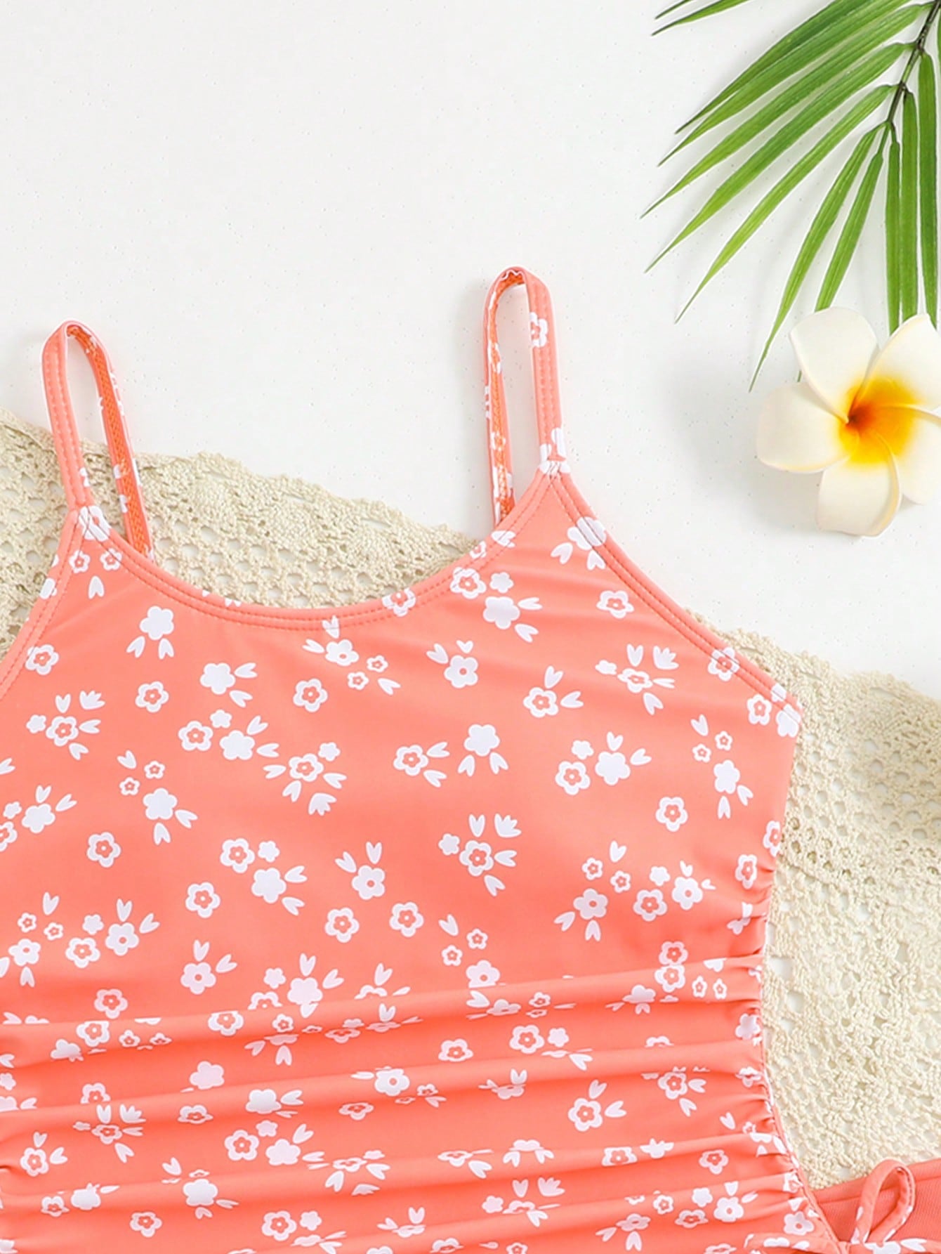Tween girls 2-piece swimsuit in black with pink floral print, featuring spaghetti straps, bow decor, mesh detail, and a skirted mid-waist bottom. Sleeveless vacation-style swim set with medium-stretch fabric.