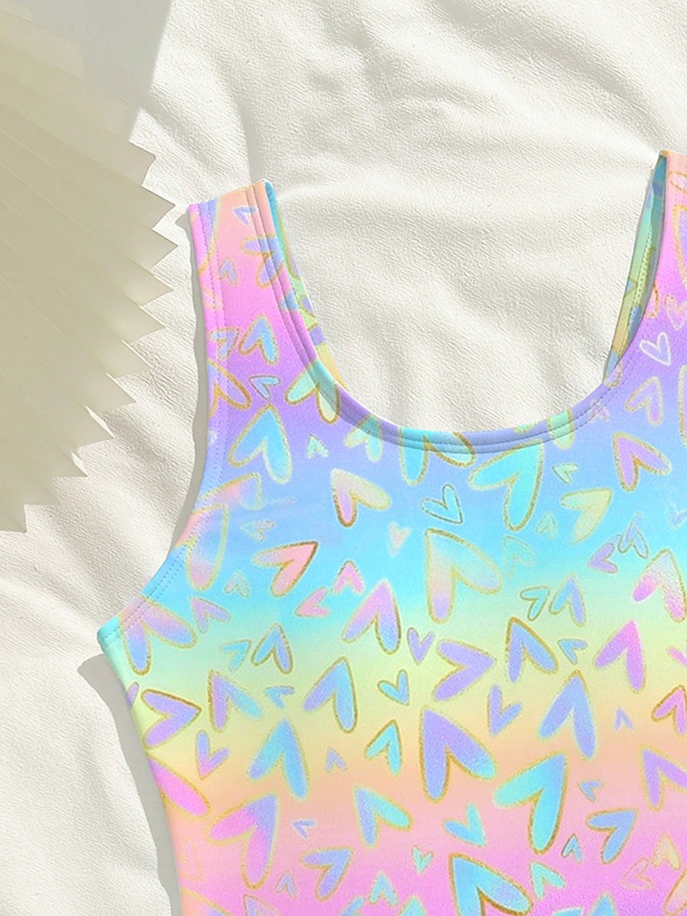 Tween girls one-piece swimsuit with a black base and multicolor tropical plant print featuring bamboo, palm leaves, plumeria flowers, scoop neck, and wide straps.
