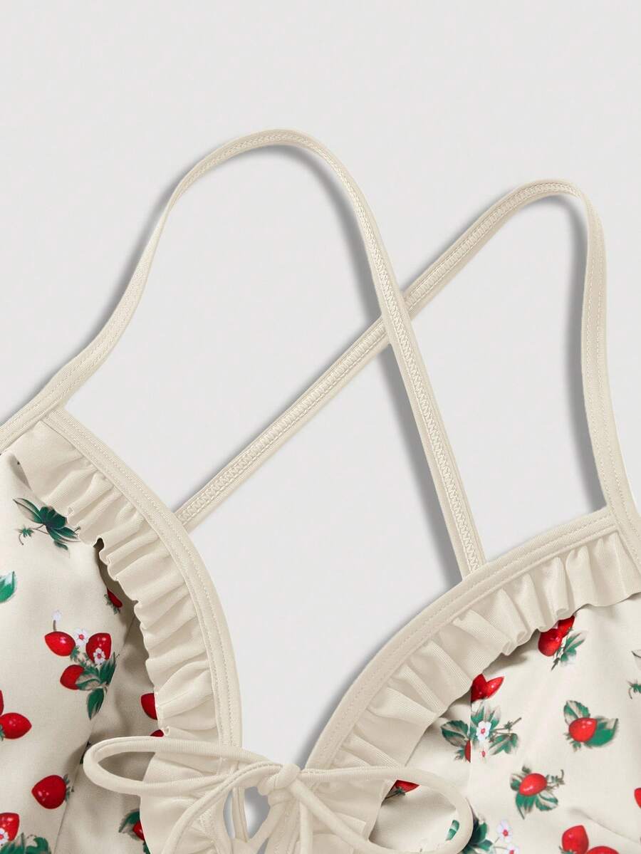 Women's strawberry print one-piece swimsuit featuring ruffle details, front-tie design, backless criss-cross straps, and triangle wireless cups.
