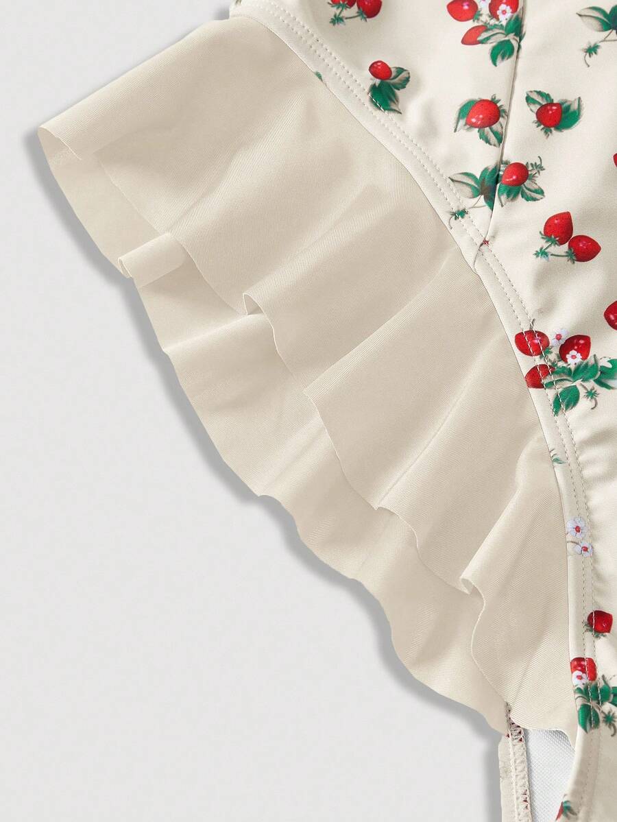 Women's strawberry print one-piece swimsuit featuring ruffle details, front-tie design, backless criss-cross straps, and triangle wireless cups.