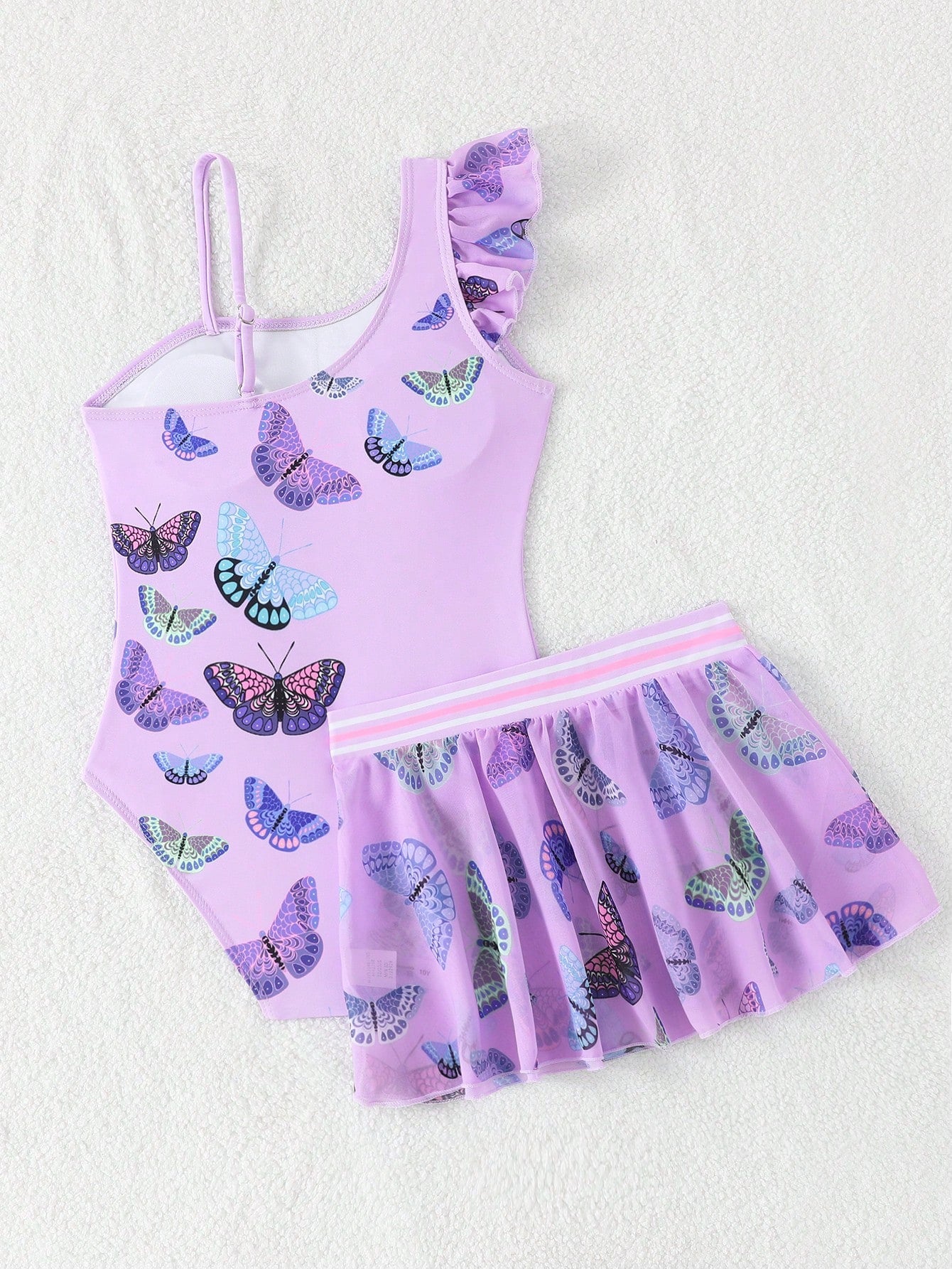 Girls yellow one-piece swimsuit with asymmetrical neckline, ruffle detail, sleeveless fitted style, and skirt bottom for beach and pool vacations.