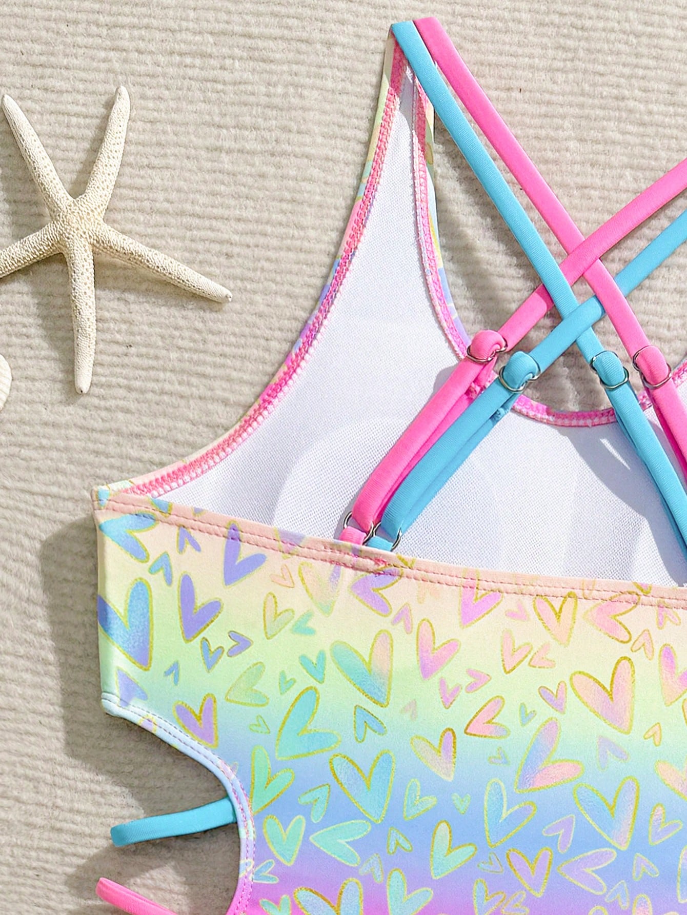 Tween girl multicolor one-piece swimsuit with gradient heart graphic print, scoop neck, cutout detail, and fitted vacation beachwear style.