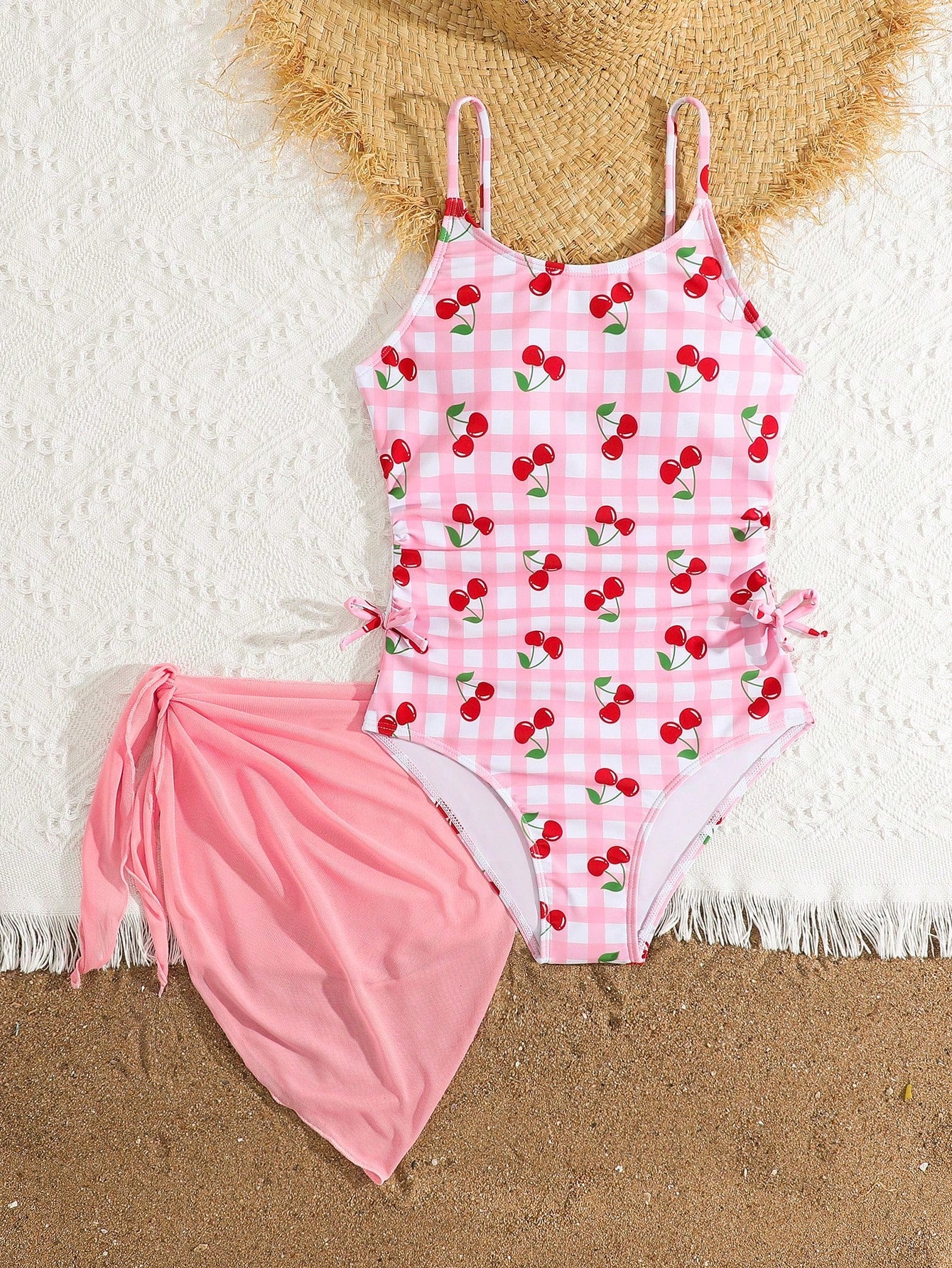 Tween girls 2-piece swimsuit in black with pink floral print, featuring spaghetti straps, bow decor, mesh detail, and a skirted mid-waist bottom. Sleeveless vacation-style swim set with medium-stretch fabric.